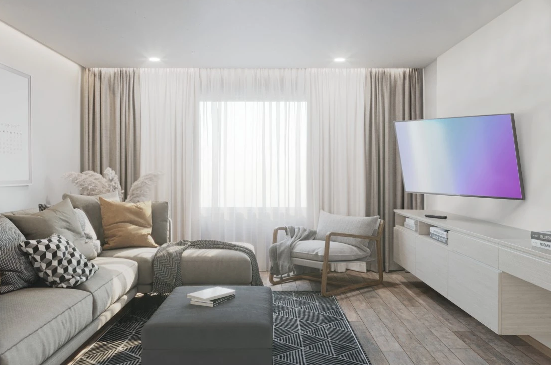 Modernes Wohnzimmer mit Sofa, Sessel, Teppich, Fernseher und Vorhängen. Holzboden und weiße Wände.