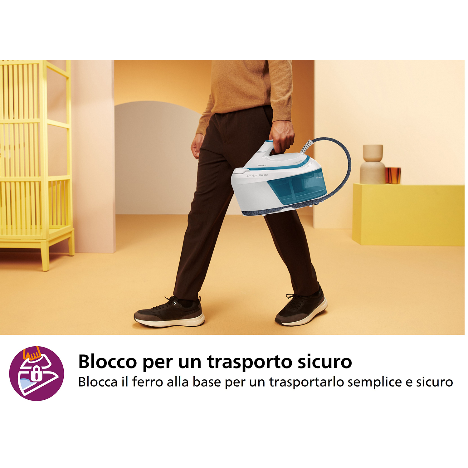 Uomo con camicia marrone che tiene un ferro da stiro turchese e bianco con manico blu, pantaloni neri e scarpe nere.