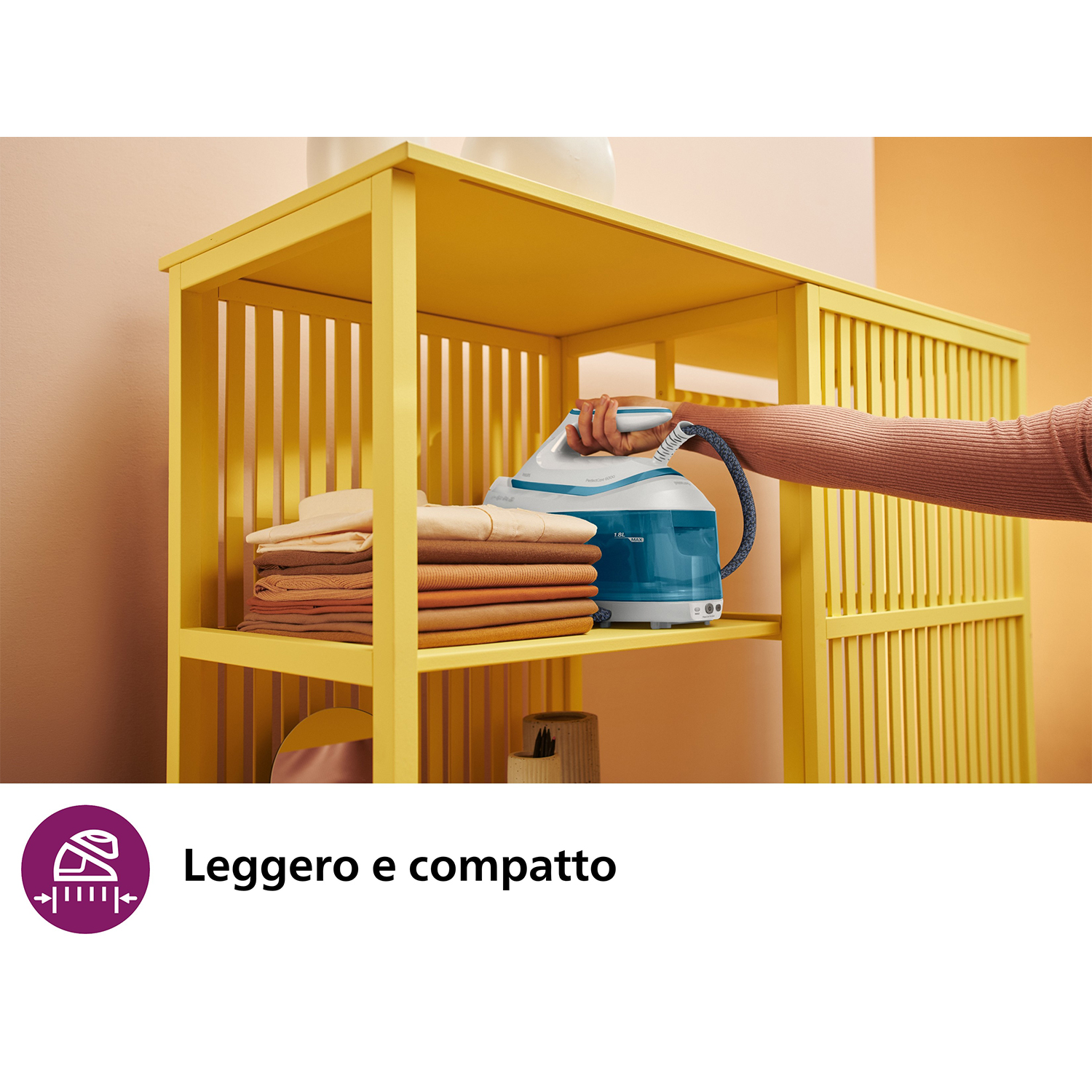 Scaffale giallo con ferro da stiro e vestiti piegati. Una donna sta raggiungendo.