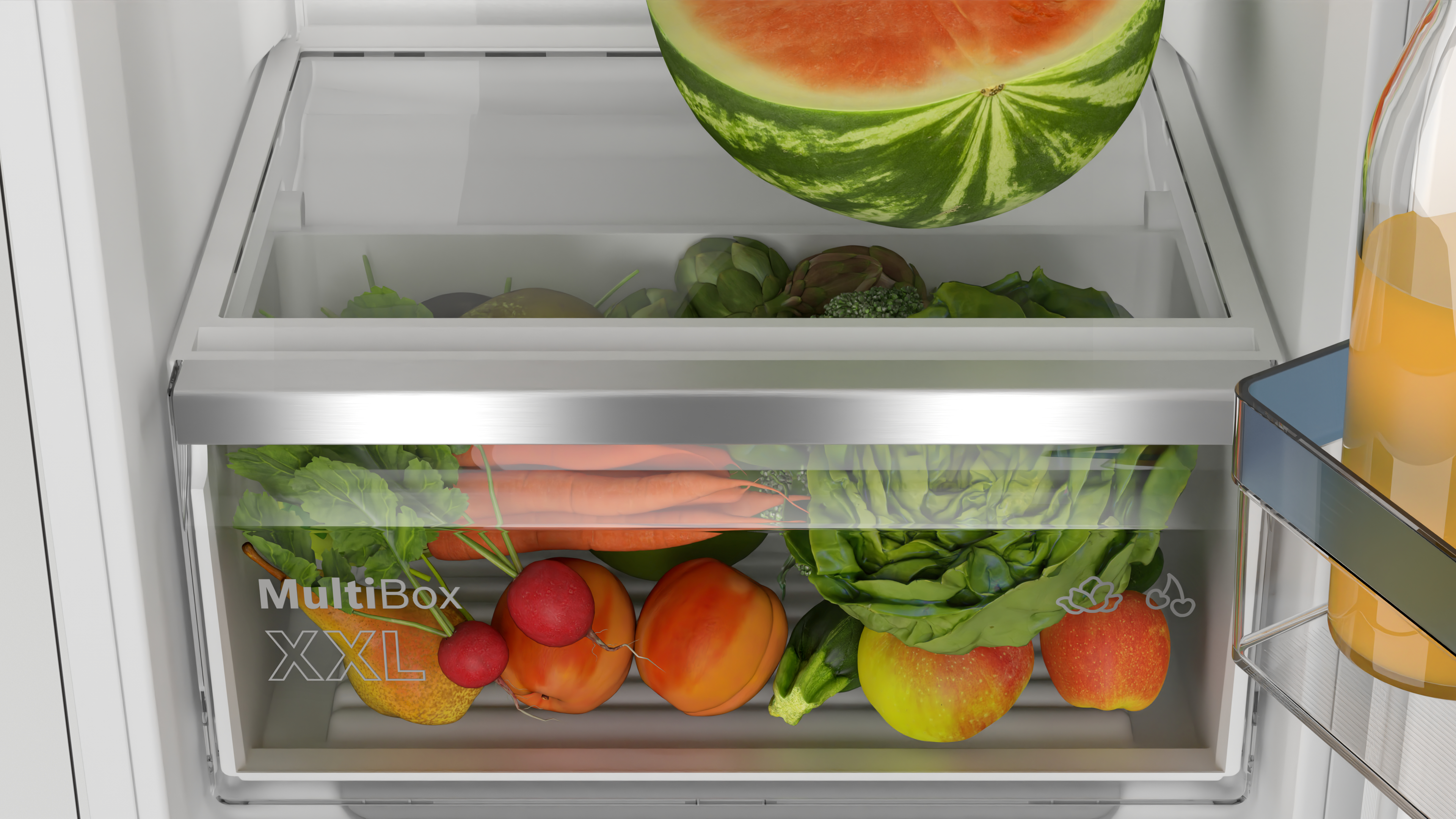 In einem Kühlschrank, ein 'MultiBox XXL' Behälter. Gefüllt mit Gemüse und einer Wassermelone oben.