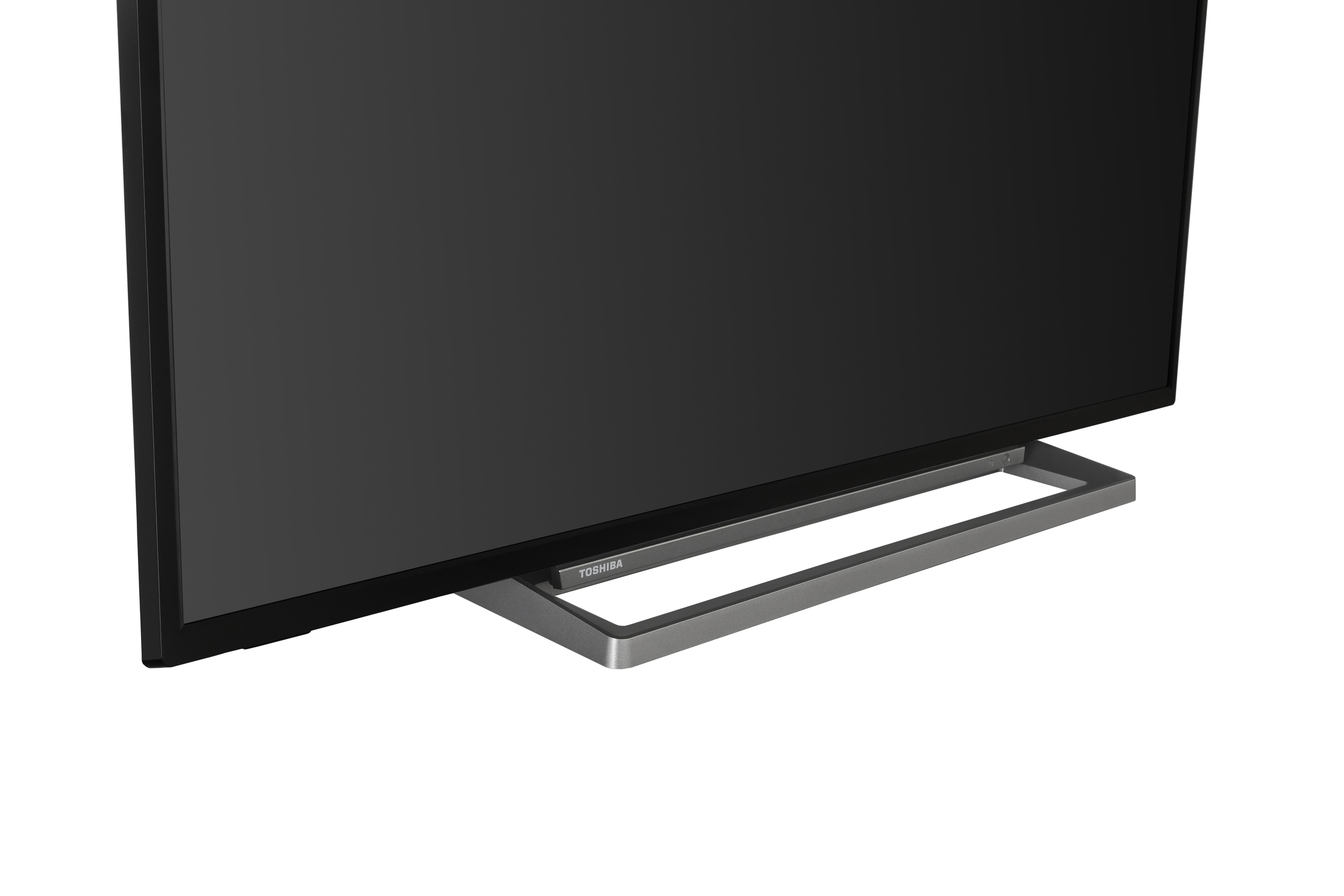 Toshiba-Fernseher, Nahaufnahme des unteren Teils. Der Fernseher ist schwarz, der Sockel ist silber.