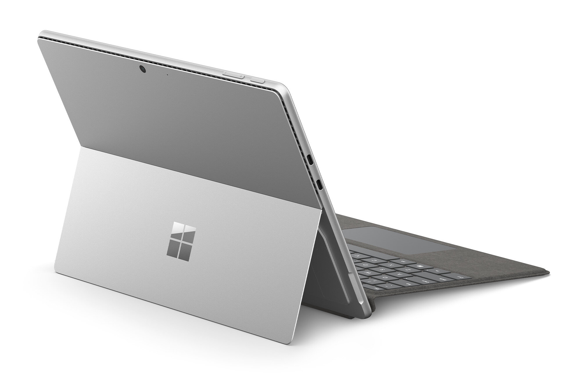 Srebrny laptop z podłączoną klawiaturą. Jest otwarty, pokazując ekran i klawiaturę.