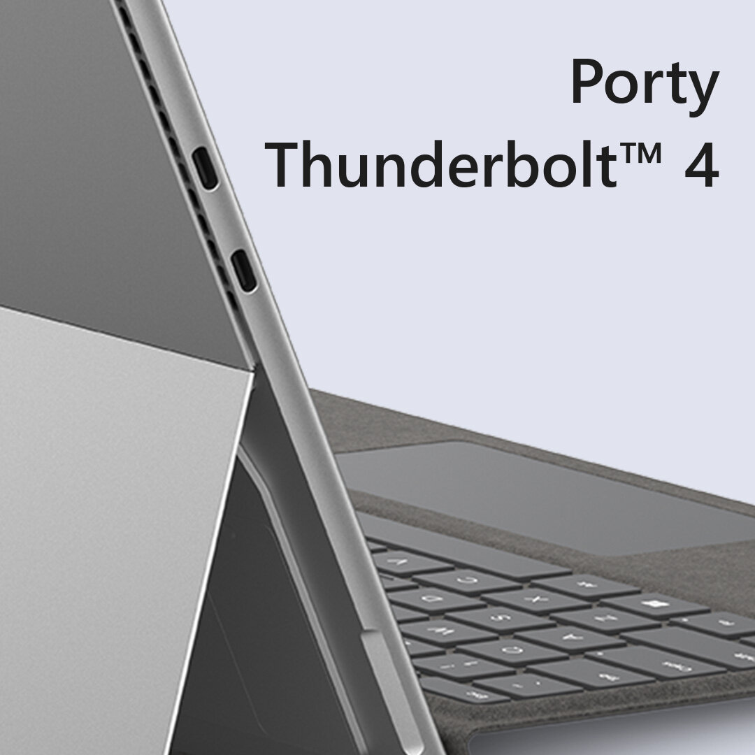 Zbliżenie laptopa. Ekran wyświetla 'Porty Thunderbolt 4'. Widoczna klawiatura i srebrna obudowa.