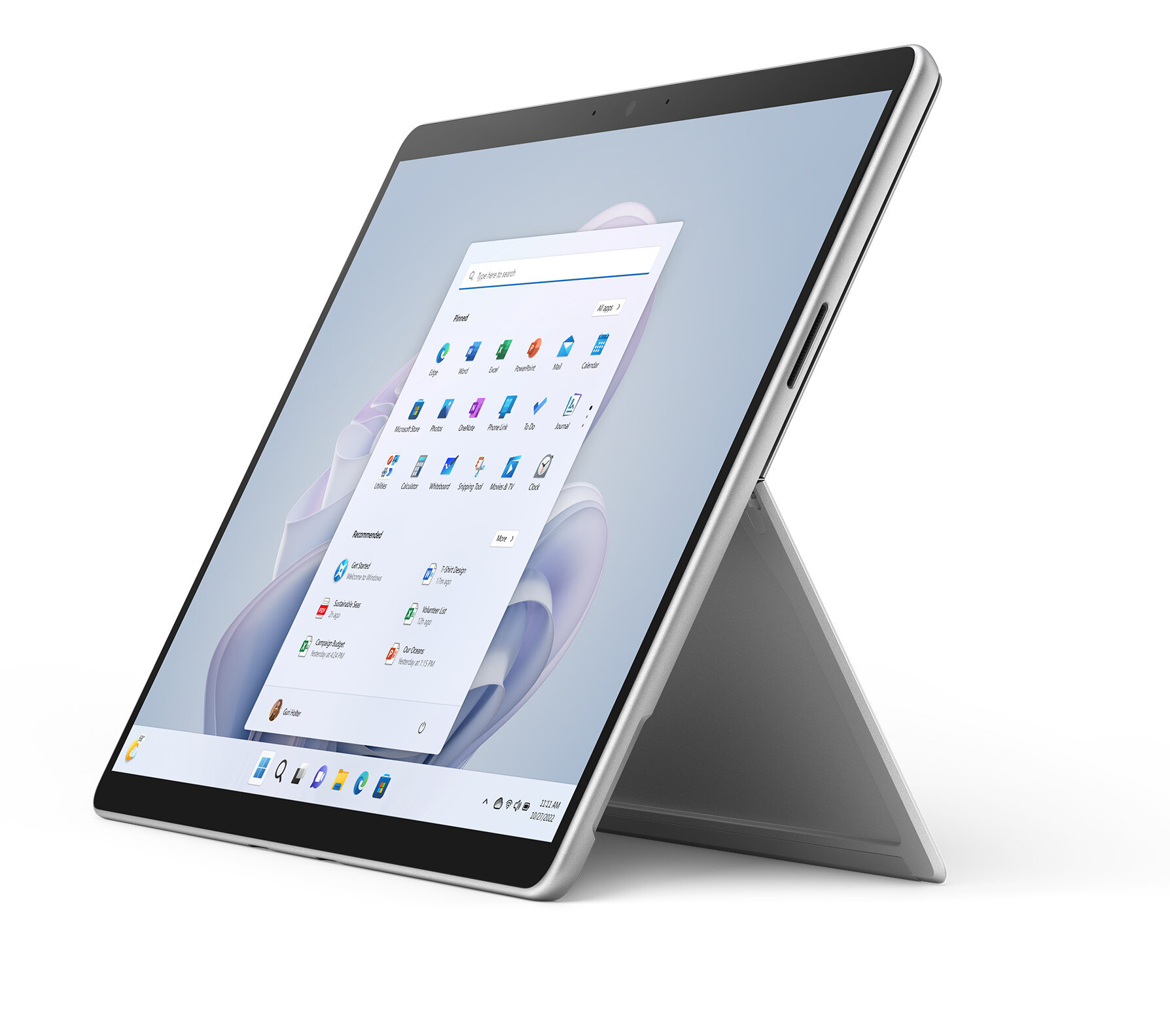 Srebrzysty tablet z interfejsem Windows 11, podparty podpórką na białej powierzchni.