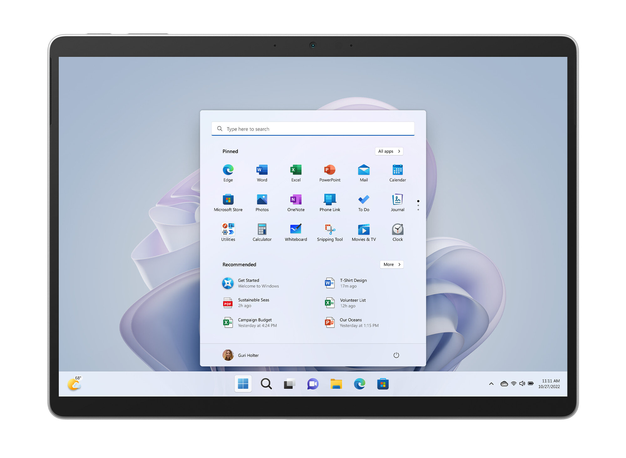 Tablet wyświetlający interfejs Windows 11 z różnymi ikonami aplikacji, na białej powierzchni.