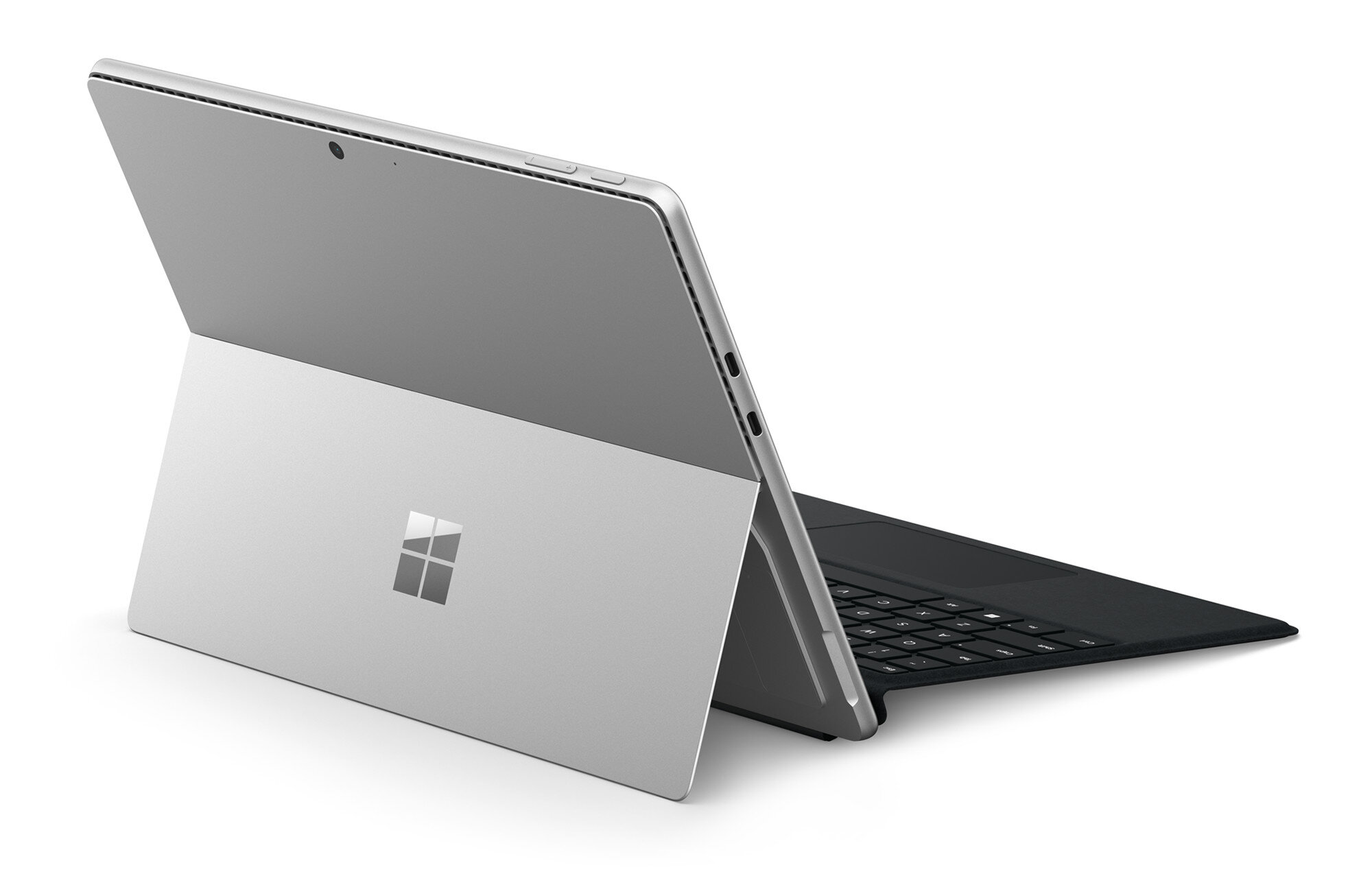 Srebrny laptop z logo Microsoft, otwarty i ustawiony pod kątem na białym tle.