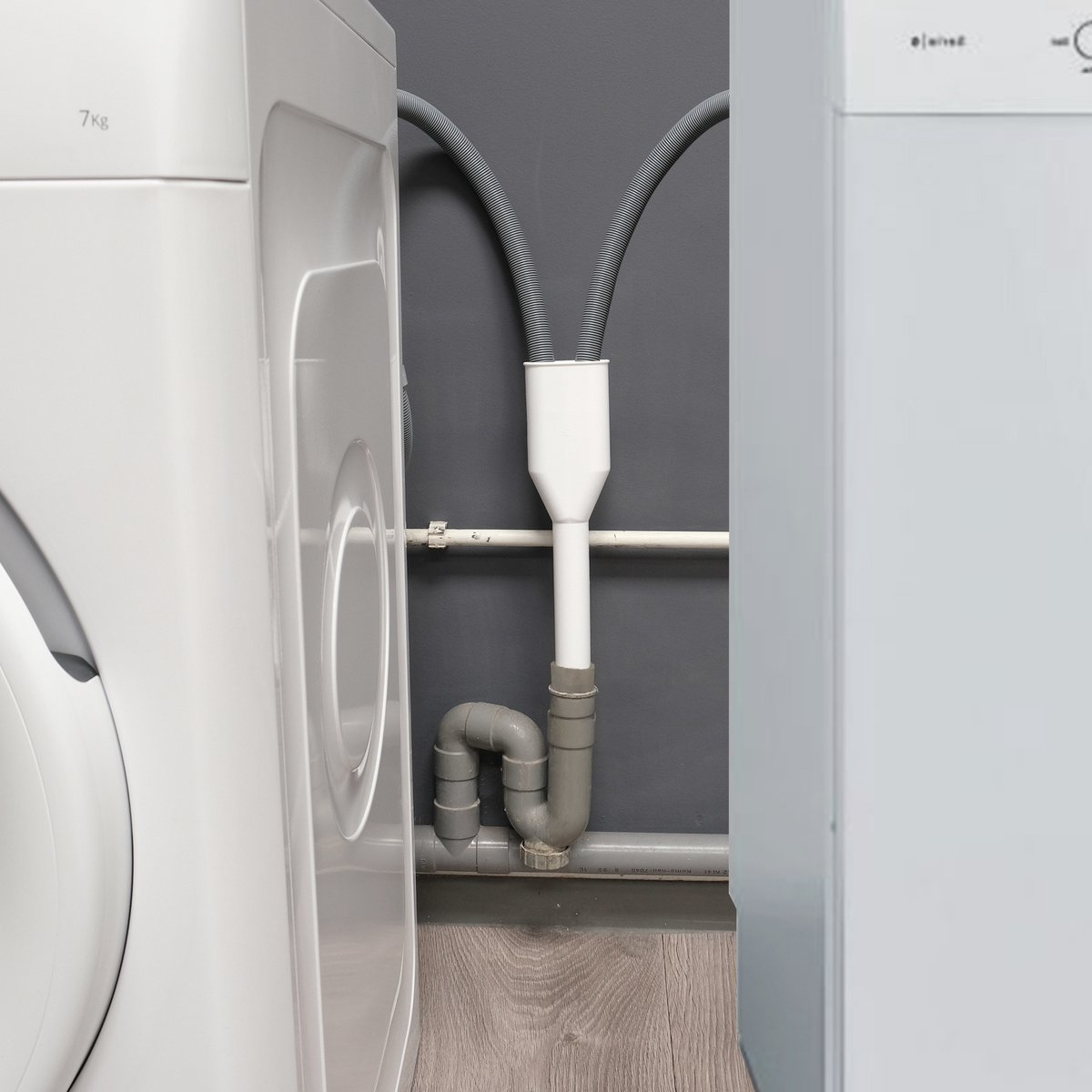 Wasmachine en droger met sanitair. Grijze muren en houten vloer.