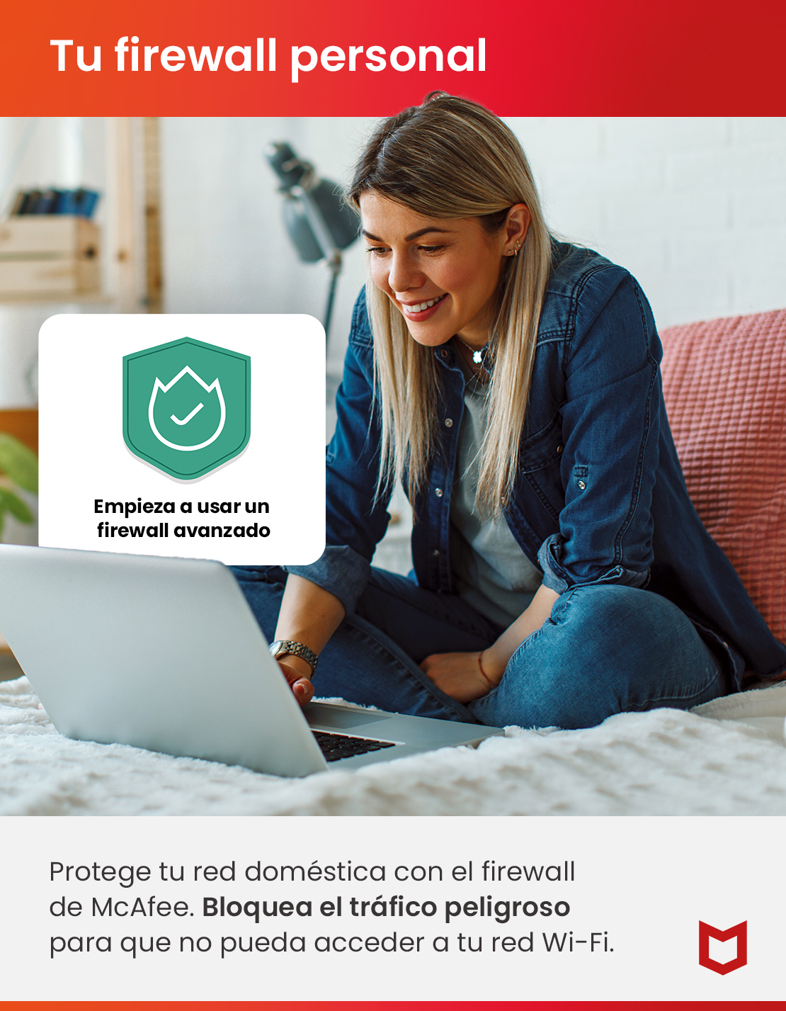Una mujer rubia está sentada en la cama, sonriendo mientras usa una computadora portátil.