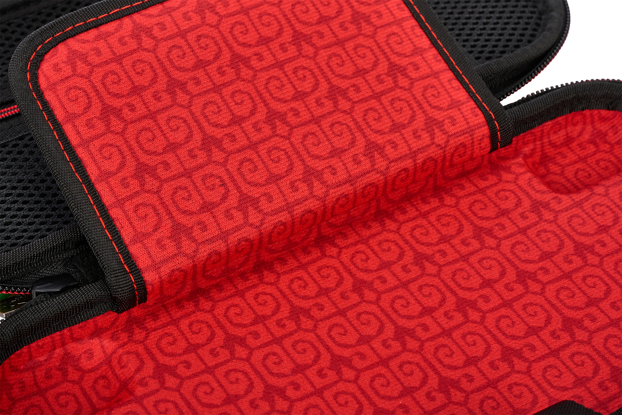 Roter Stoff mit Muster, schwarzer Rand und Reißverschluss.