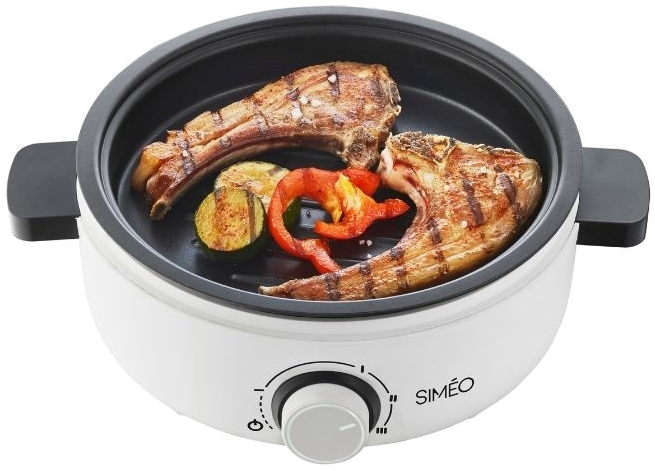 A white grill with grilled meat and vegetables inside.