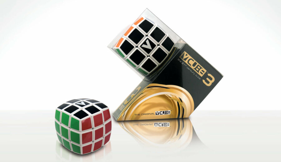 Rubik-kocka egy dobozban. A kocka fekete-fehér. A doboz átlátszó és arany, fehér háttér.