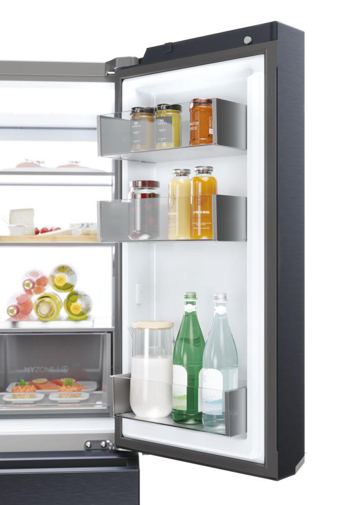 Geöffneter Kühlschrank mit Regalen, die Gläser, Saftflaschen und Wasser- und Milchflaschen enthalten.