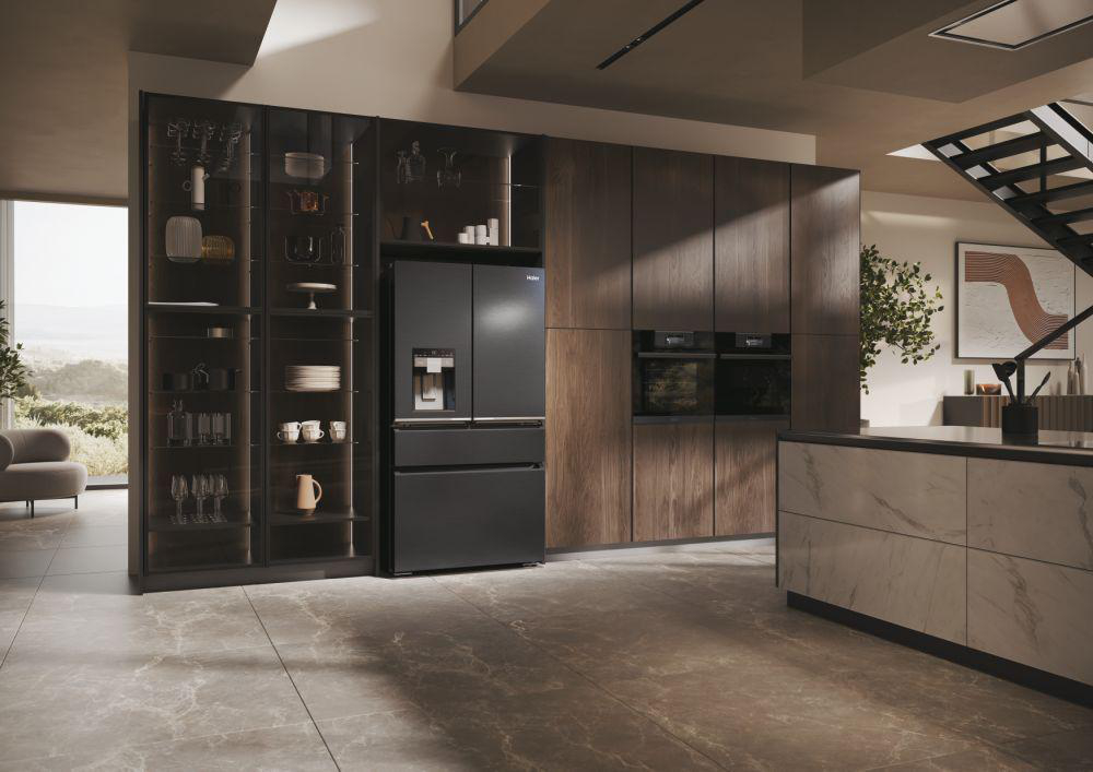 Schwarzer Kühlschrank in luxuriöser Küche. Holzschränke, Glasvitrinen, Treppe sichtbar.