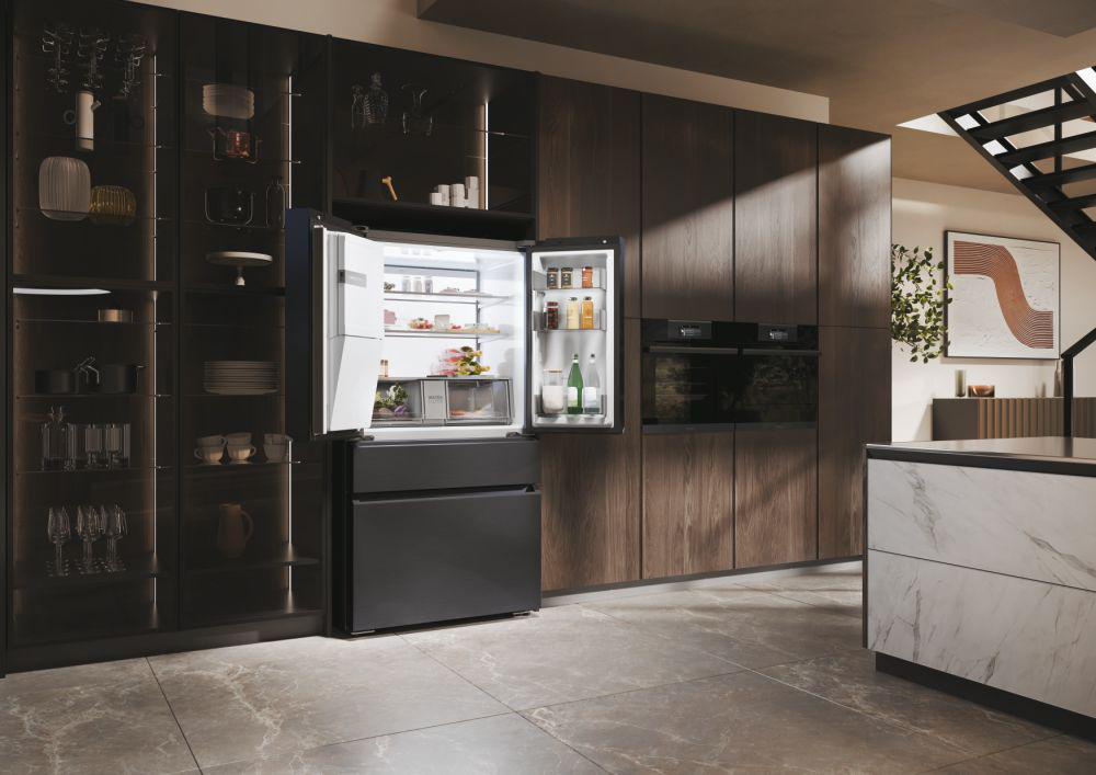 Schwarzer Kühlschrank mit offenen Türen voller Essen, in Küche mit Holzschränken und Marmorboden.