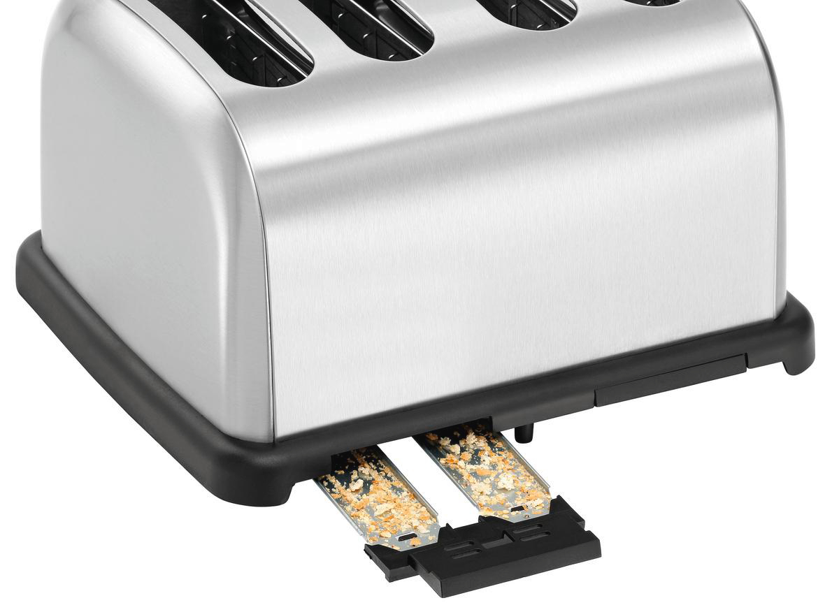 Ein Toaster aus Edelstahl mit herausgezogenen Krümelschubladen. Brotkrumen sind in den Schubladen sichtbar. Der Toaster hat vier Schlitze.