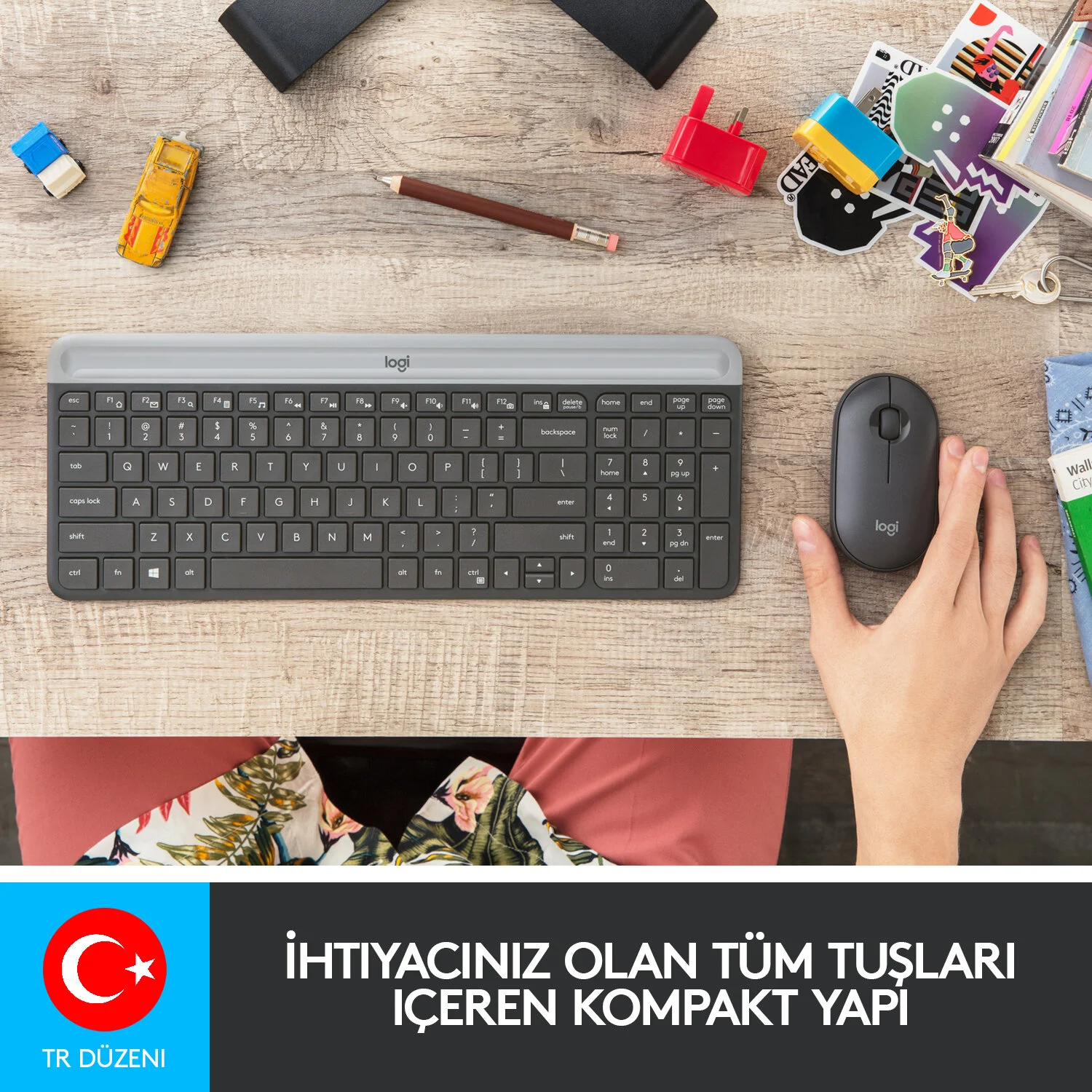Bir klavye, fare ve diğer masa öğelerinin bulunduğu bir masa. Klavye gri renkte.