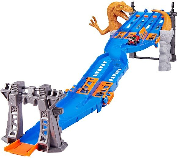 Tor Hot Wheels o tematyce dinozaurów z trzema torami. Samochody ścigają się po torze.