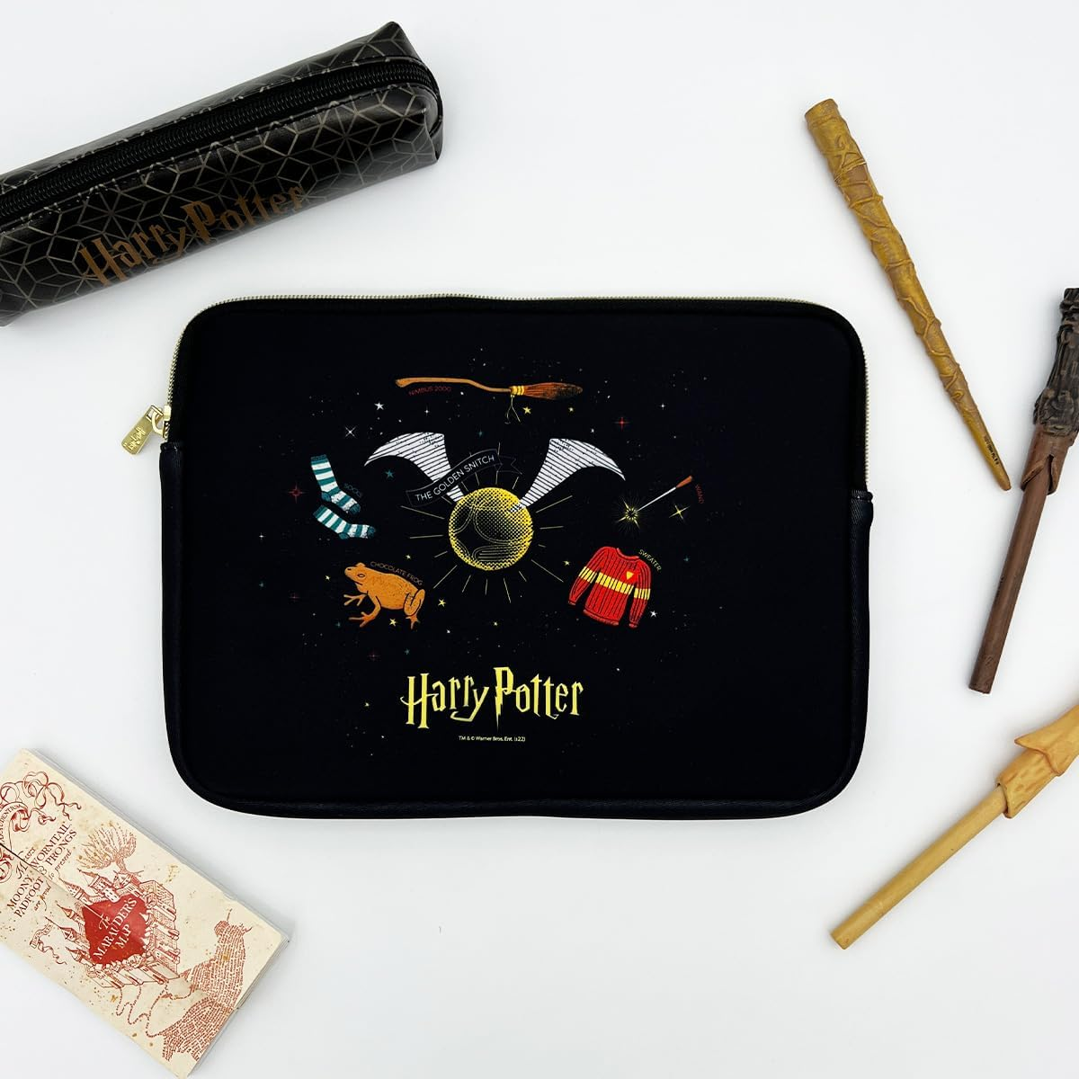 Funda para portátil temática de Harry Potter con artículos como varita, gafas y escoba en blanco.