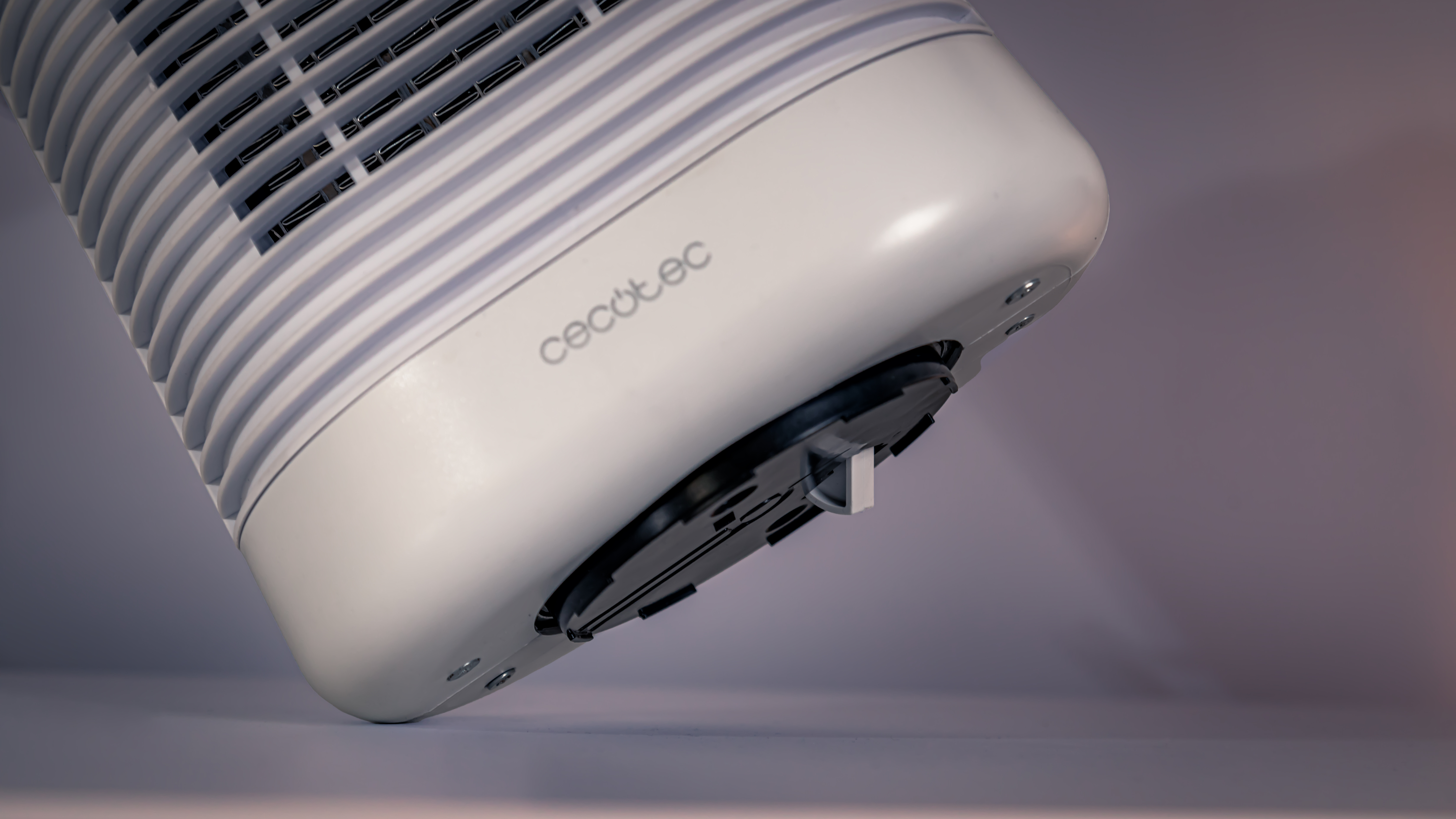 Una base de ventilador Cecotec blanca y gris. El ventilador tiene una rejilla metálica.