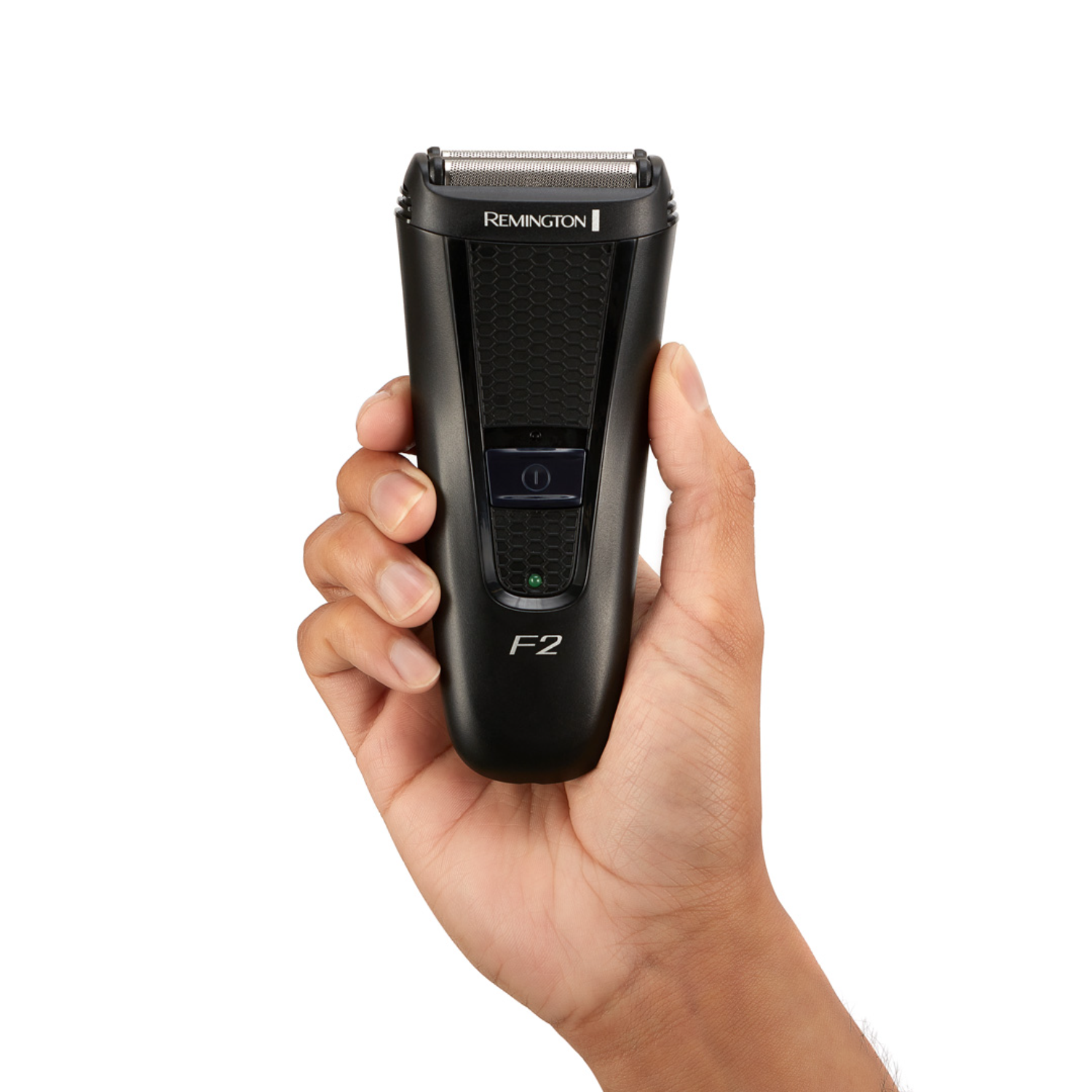 A hand holding a black Remington F2 shaver with a green power indicator. White background.