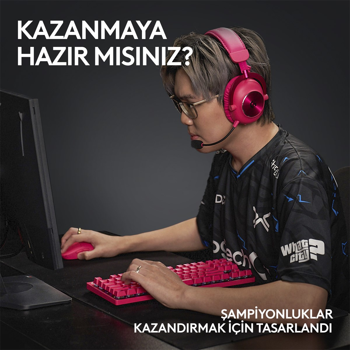 Pembe kulaklık takan, pembe klavye ve fare kullanan bir oyuncu. Karanlık arka plan.