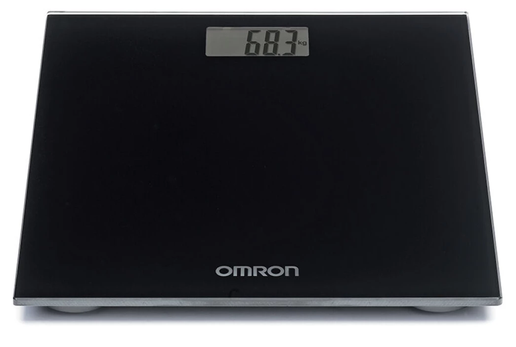 Egy fekete digitális mérleg, amely 68,3 kg-ot mutat. Az Omron márkanév látható.