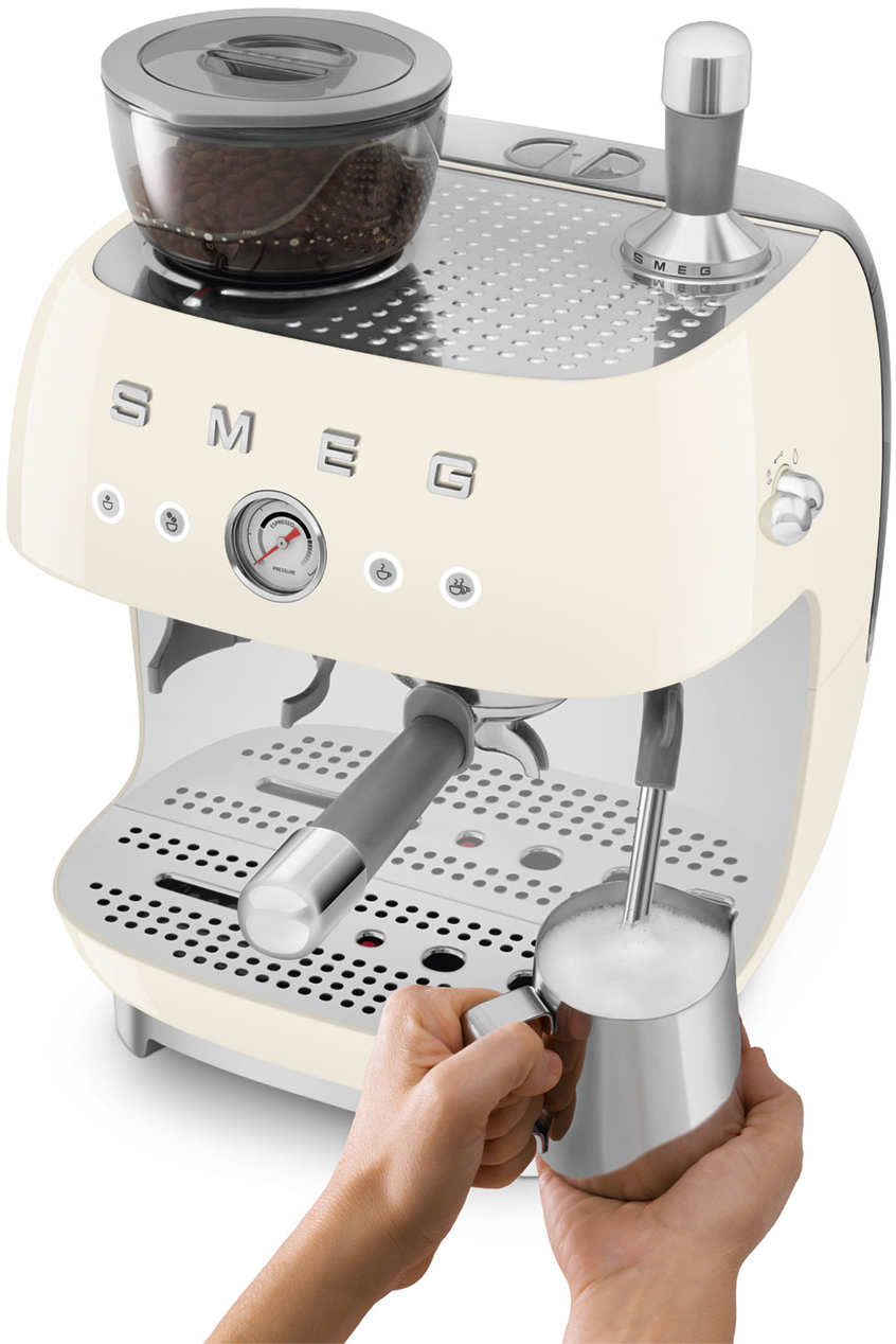 Beige Smeg Espressomaschine mit einer Hand, die Milch aufschäumt.