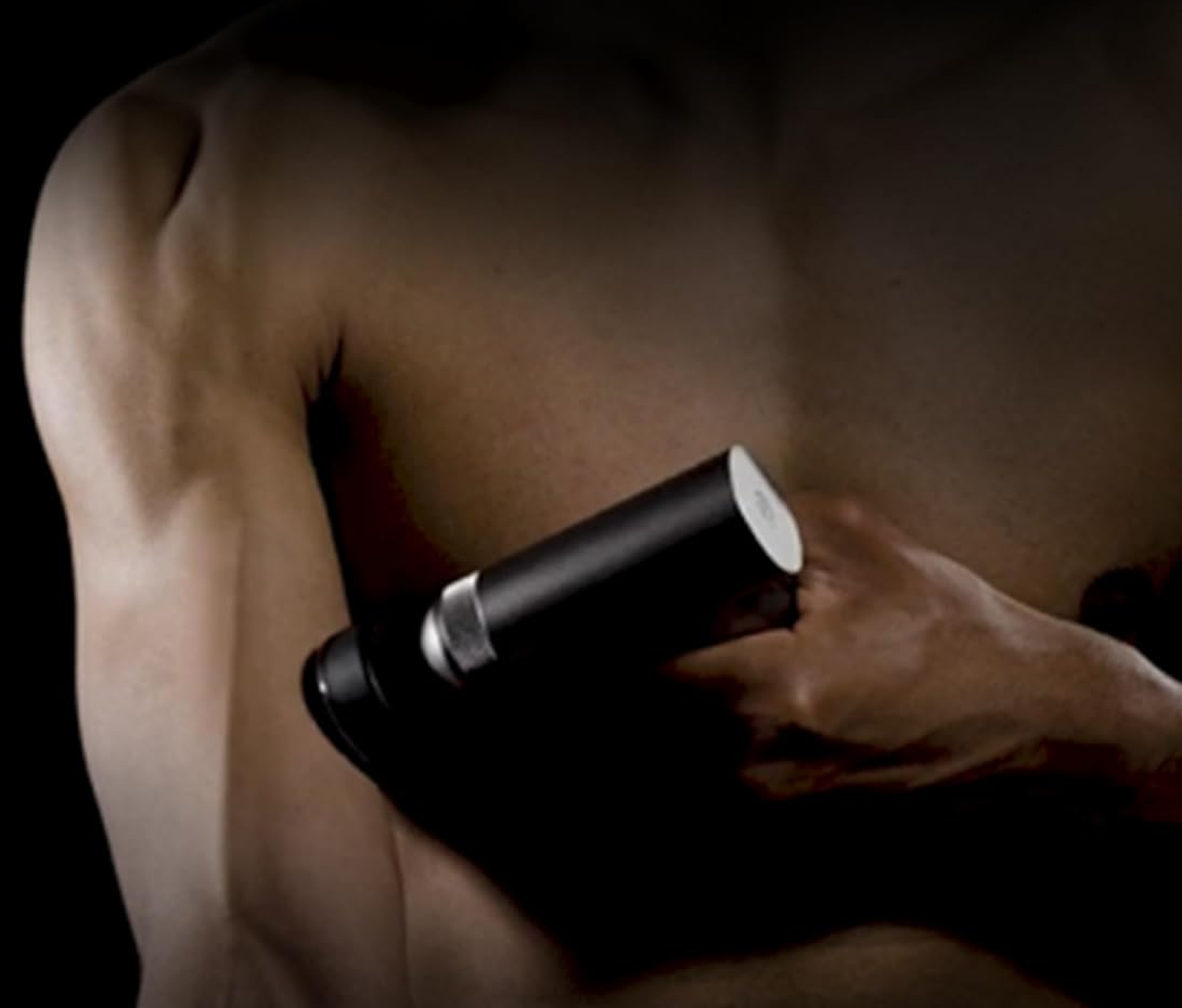 Eine Person hält eine schwarze Massagepistole, zeigt das Gerät und ihren Arm.