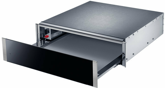 Otwarta czarna szuflada ze srebrnym wykończeniem, wewnątrz większego metalowego urządzenia.