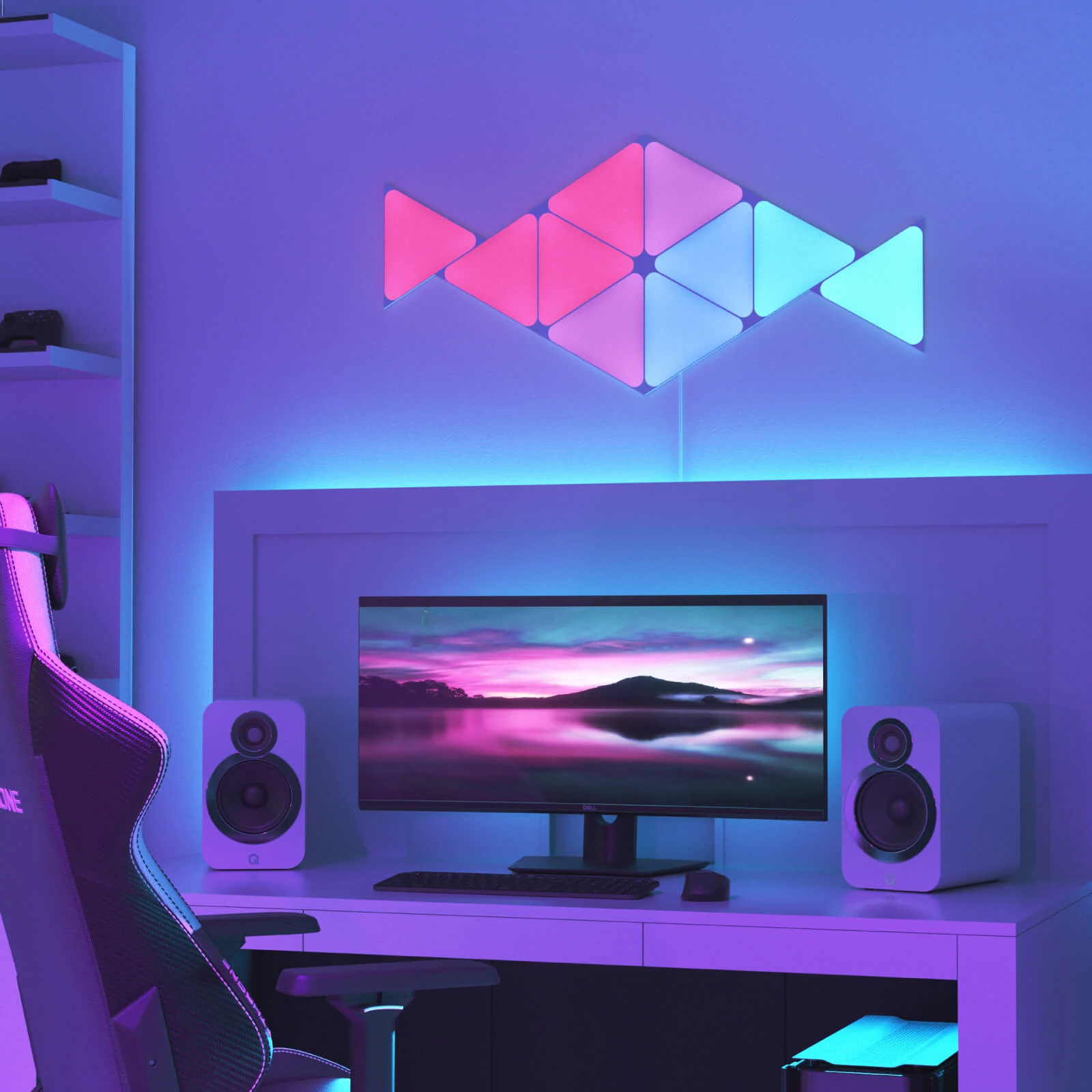 Gaming-Setup mit Wandleuchten, Monitor, Lautsprechern und Gaming-Stuhl.