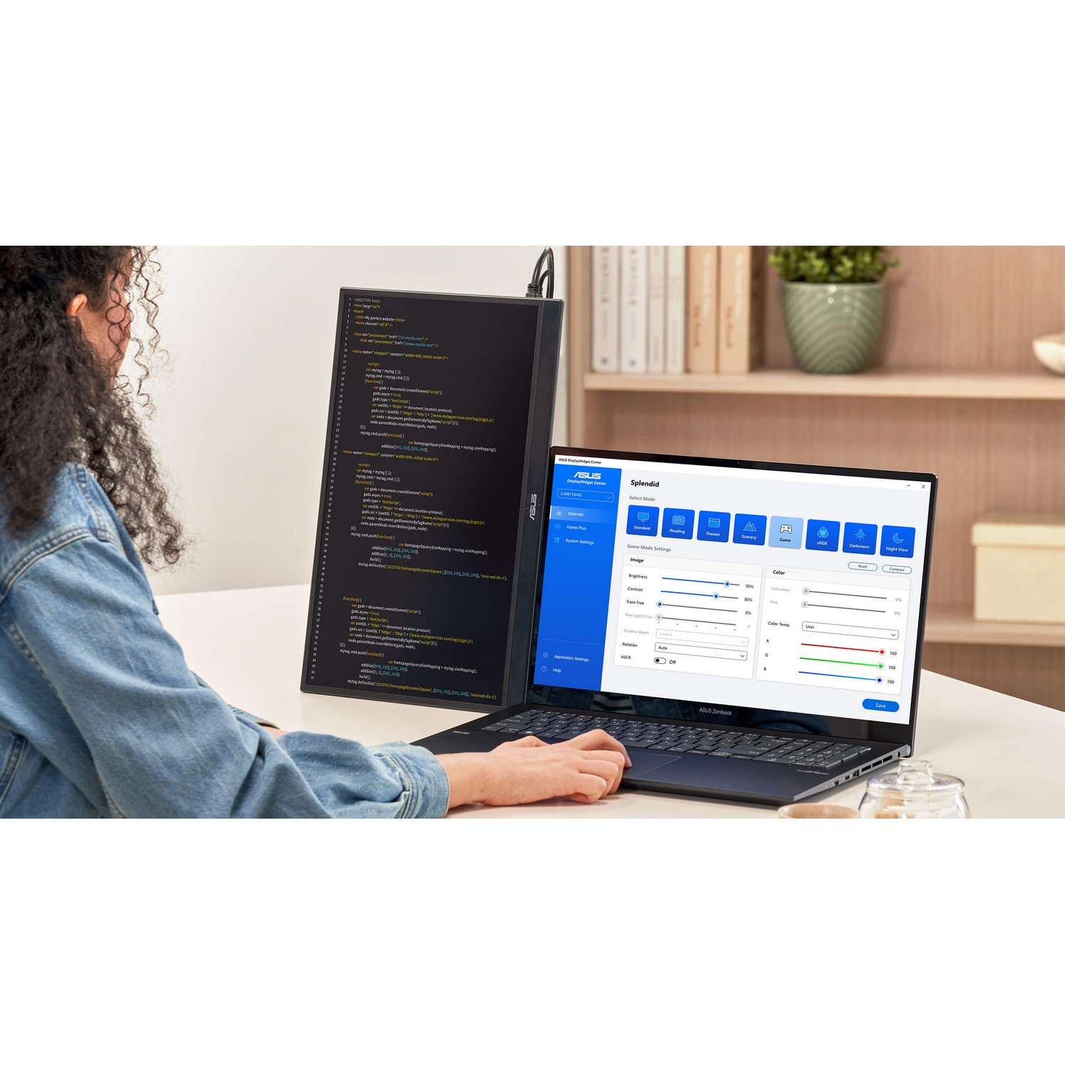 Une femme utilisant un ordinateur portable avec un second écran affichant du code.