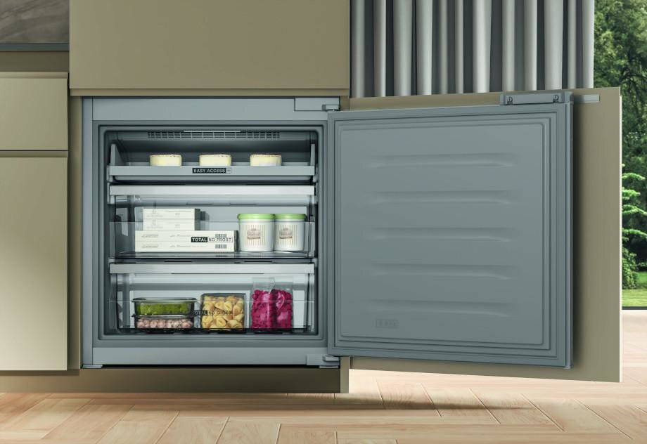 Lodówka z otwartymi drzwiami pokazująca półki wypełnione jedzeniem.