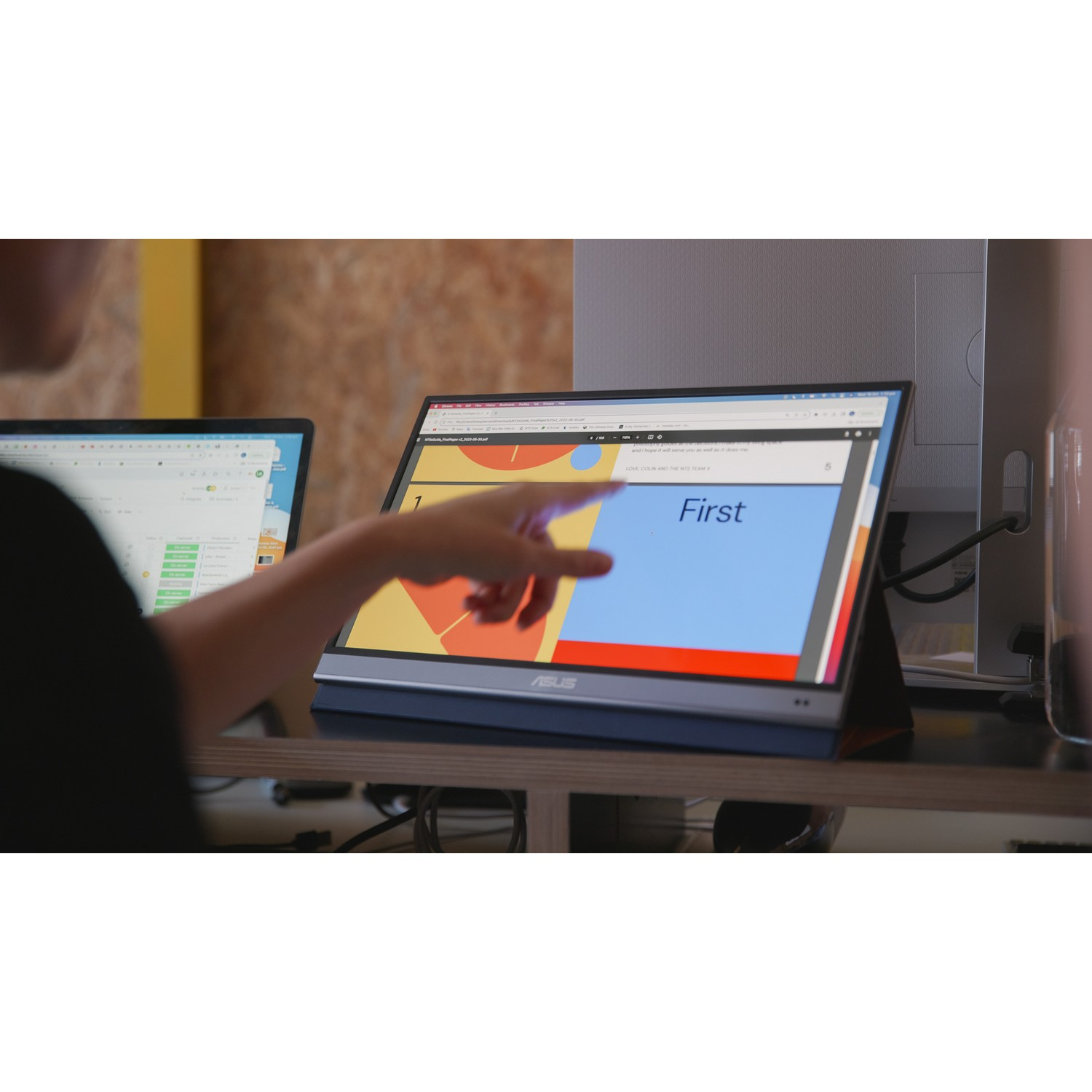 Personne pointant vers un écran avec 'First', autre écran visible.