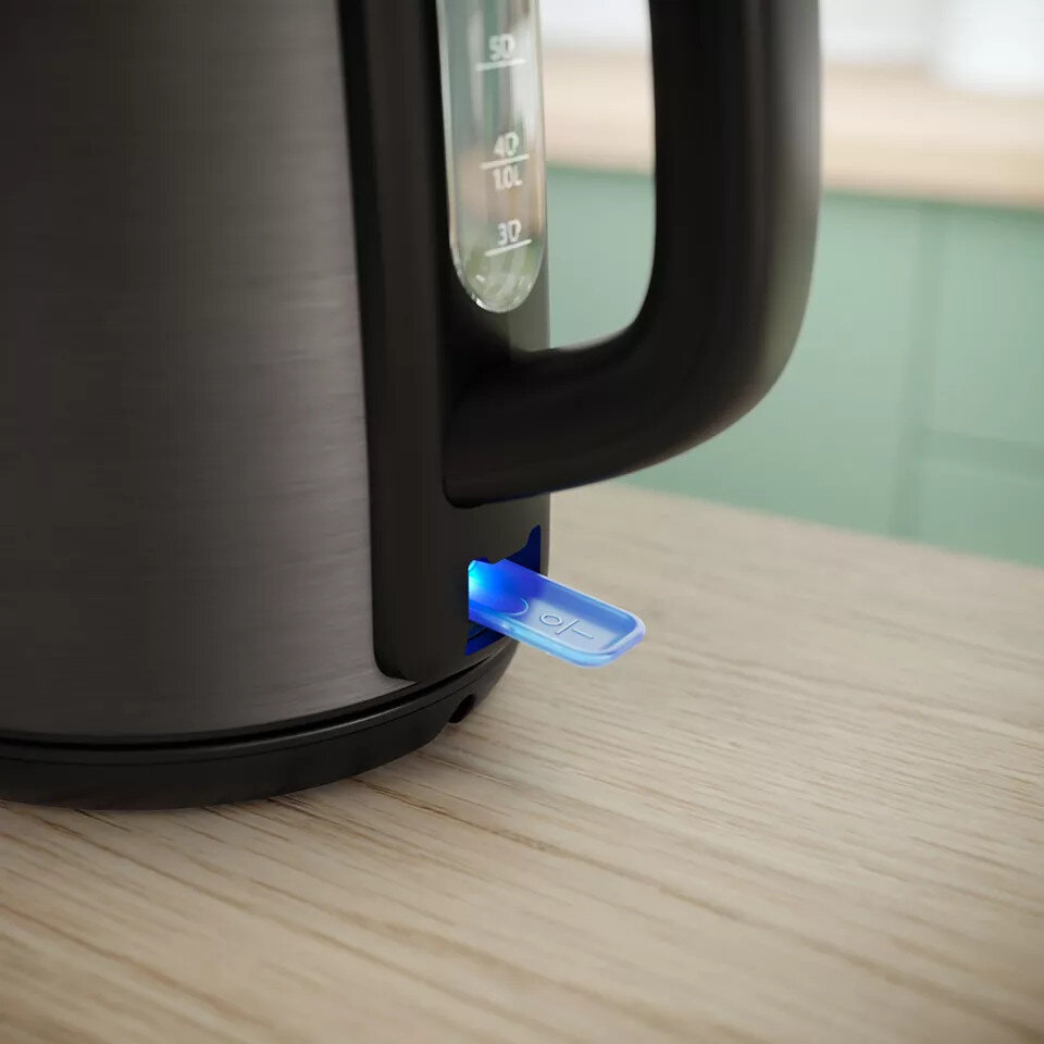Czarny czajnik elektryczny z niebieskim światłem na włączniku i wskaźnikiem poziomu wody.