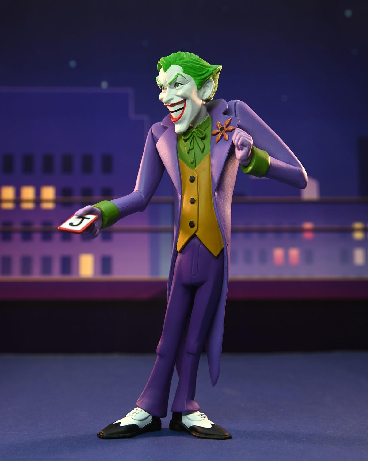 Joker-Figur hält eine Karte mit einer '5'. Lila Anzug, grüne Haare, lächelnd, auf einem Dach bei Nacht.