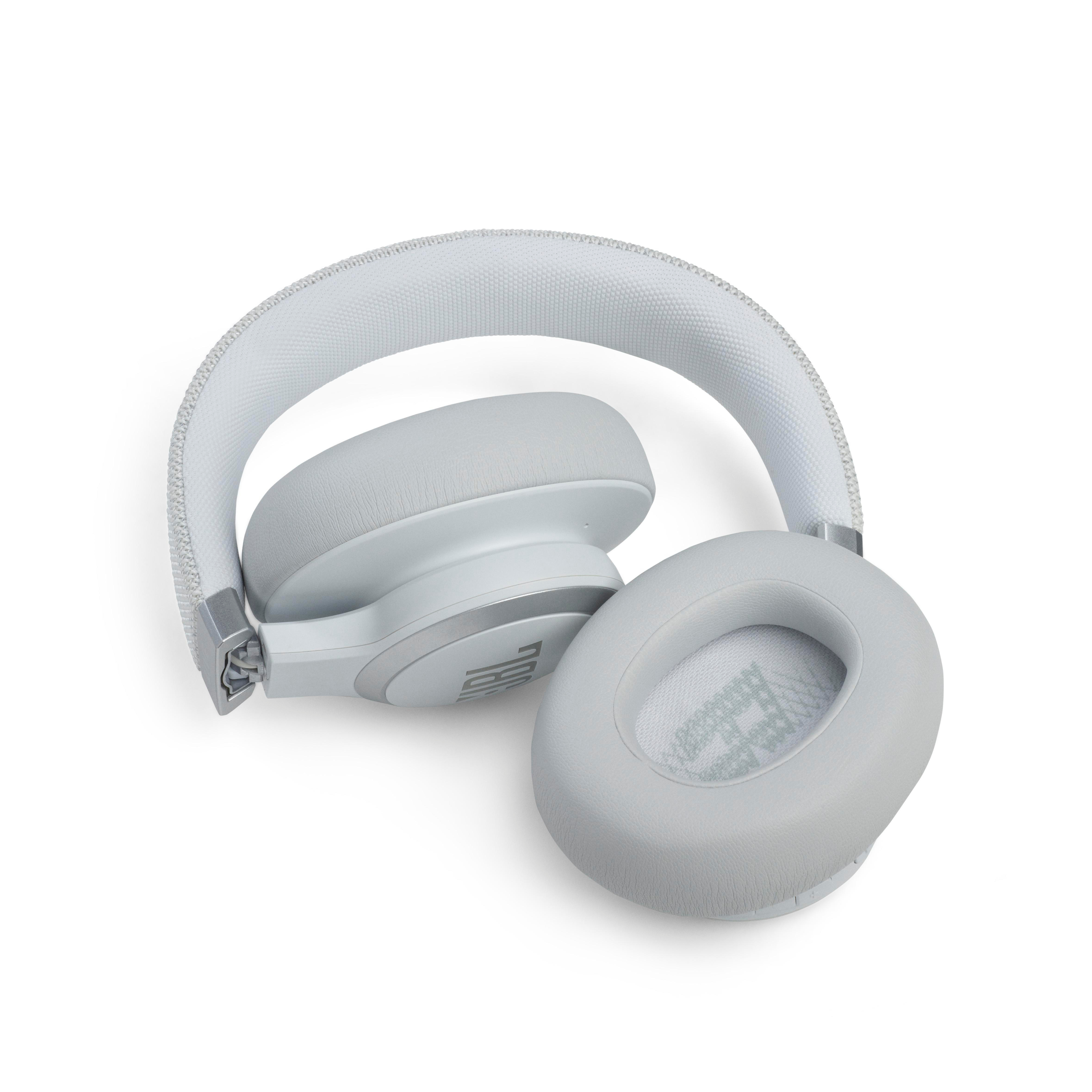 Weiße JBL-Kopfhörer offen auf weißer Oberfläche, Ohrmuscheln und Kopfbügel zeigend.