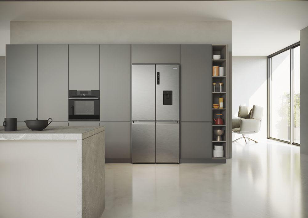 Eine moderne Küche mit grauen Schränken, einem Kühlschrank und einer weißen Arbeitsplatte.
