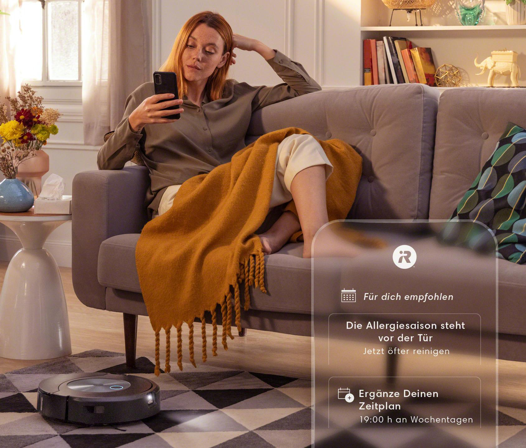 Frau auf Couch mit Handy, Roboter-Staubsauger am Boden, Text-Overlay über Reinigung.