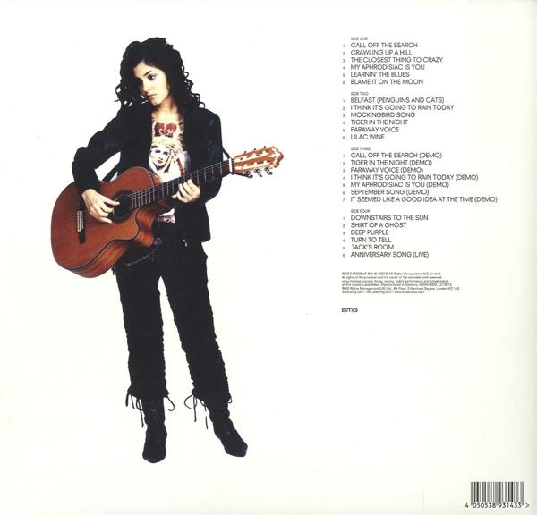 Eine Frau mit Gitarre auf einem Vinyl-Schallplatten-Cover. Sie trägt ein schwarzes Outfit und Stiefel.
