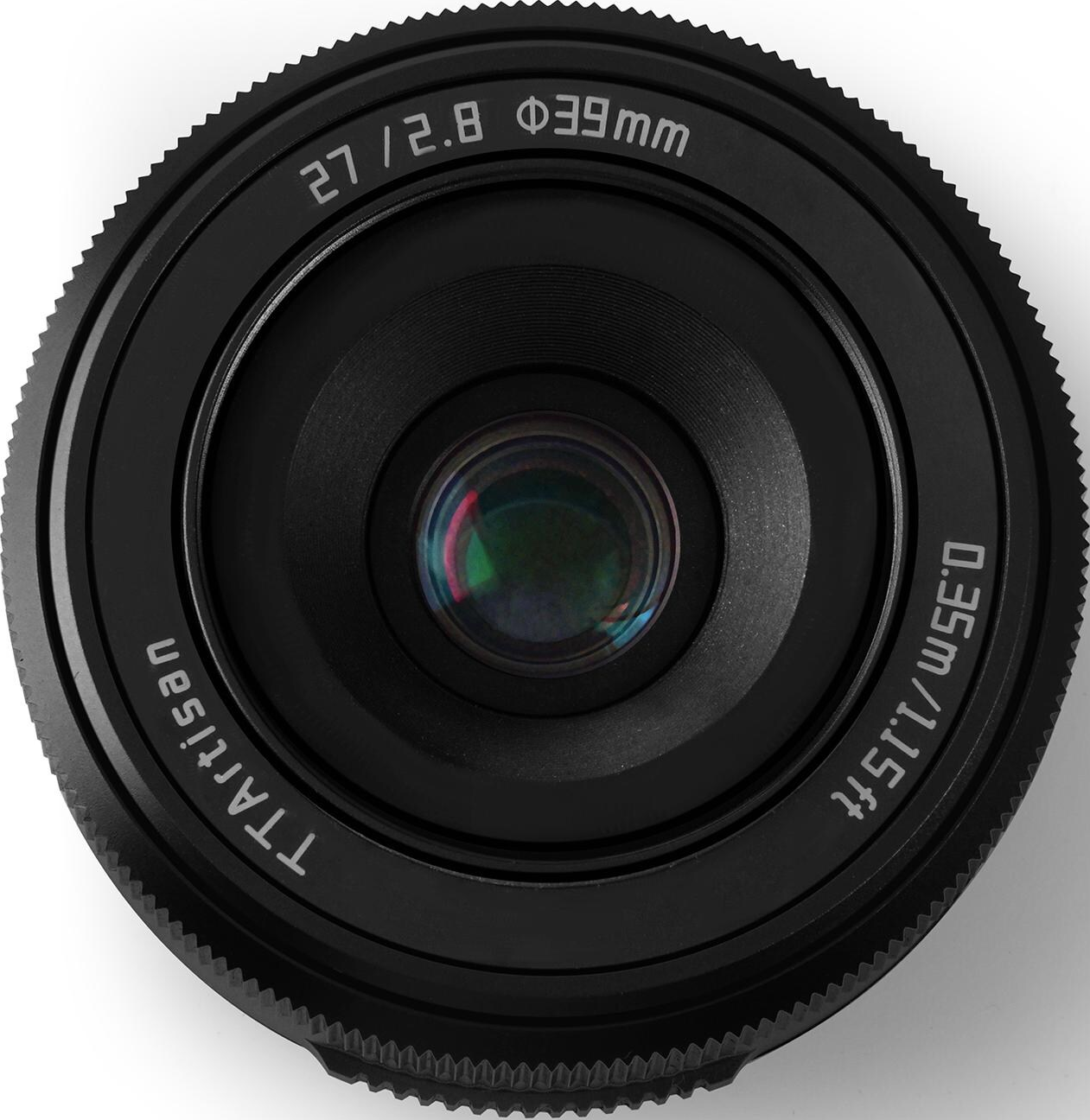 Nahaufnahme eines schwarzen Kameraobjektivs. Markierungen umfassen: 27/2.8, φ39mm, 0,35m/1,15ft und TTA artisan. Das Objektiv ist auf weißem Hintergrund.