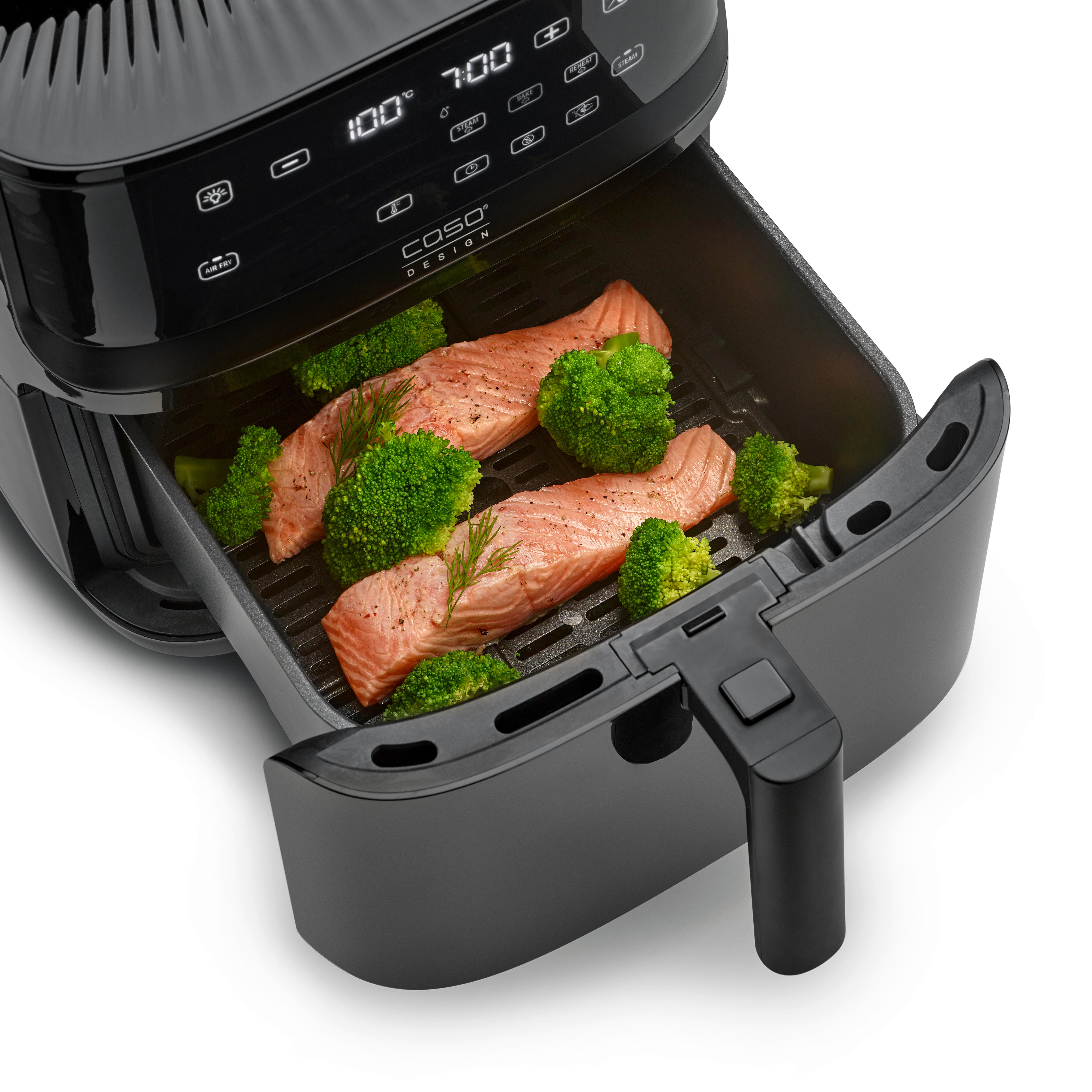 Schwarze Airfryer-Schublade geöffnet, mit Lachsfilets und Brokkoli. Schwarzer Griff und Bedienelemente sichtbar.