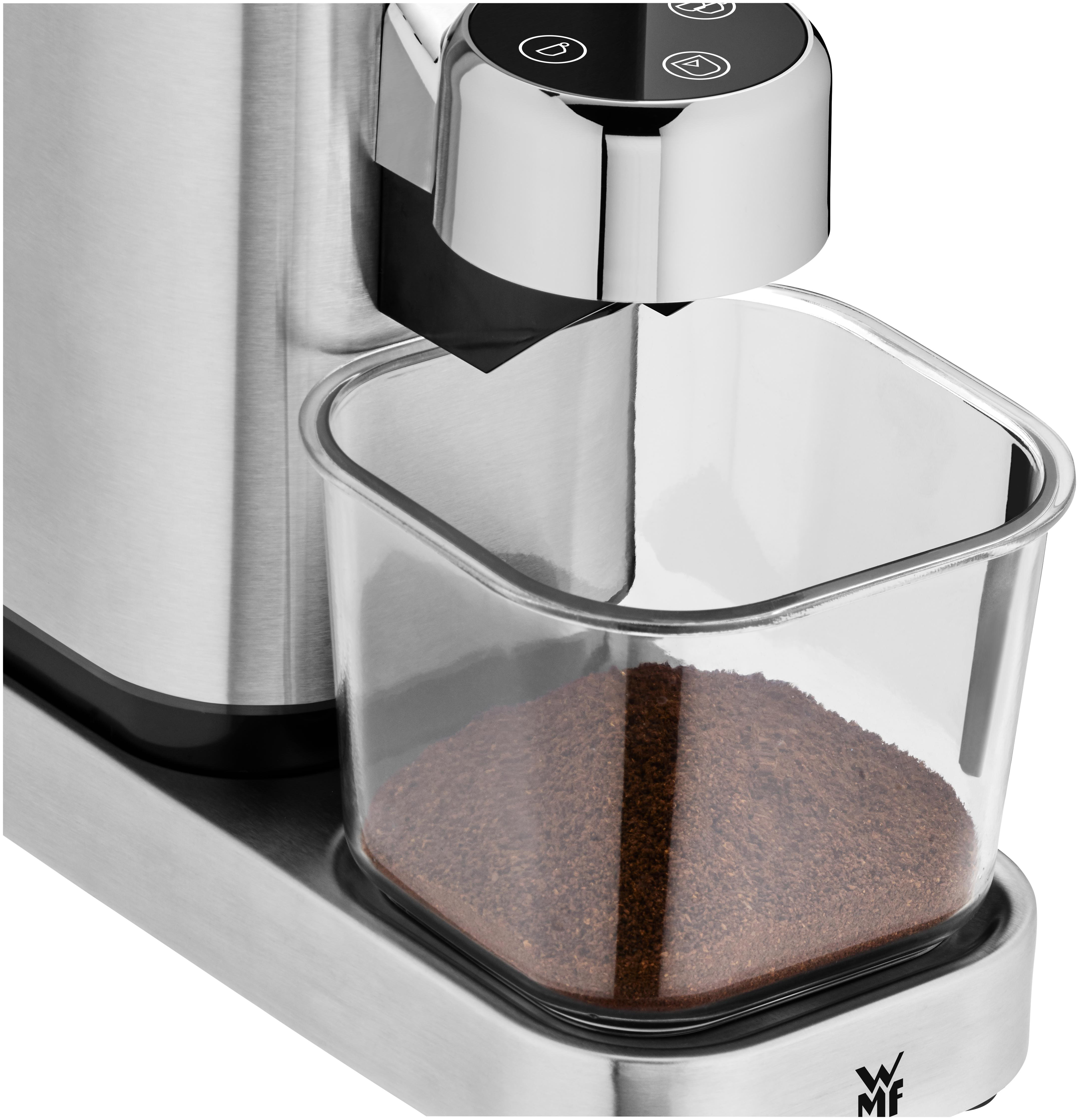 Nahaufnahme einer Kaffeemühle mit einem Behälter, gefüllt mit gemahlenen Kaffeebohnen.