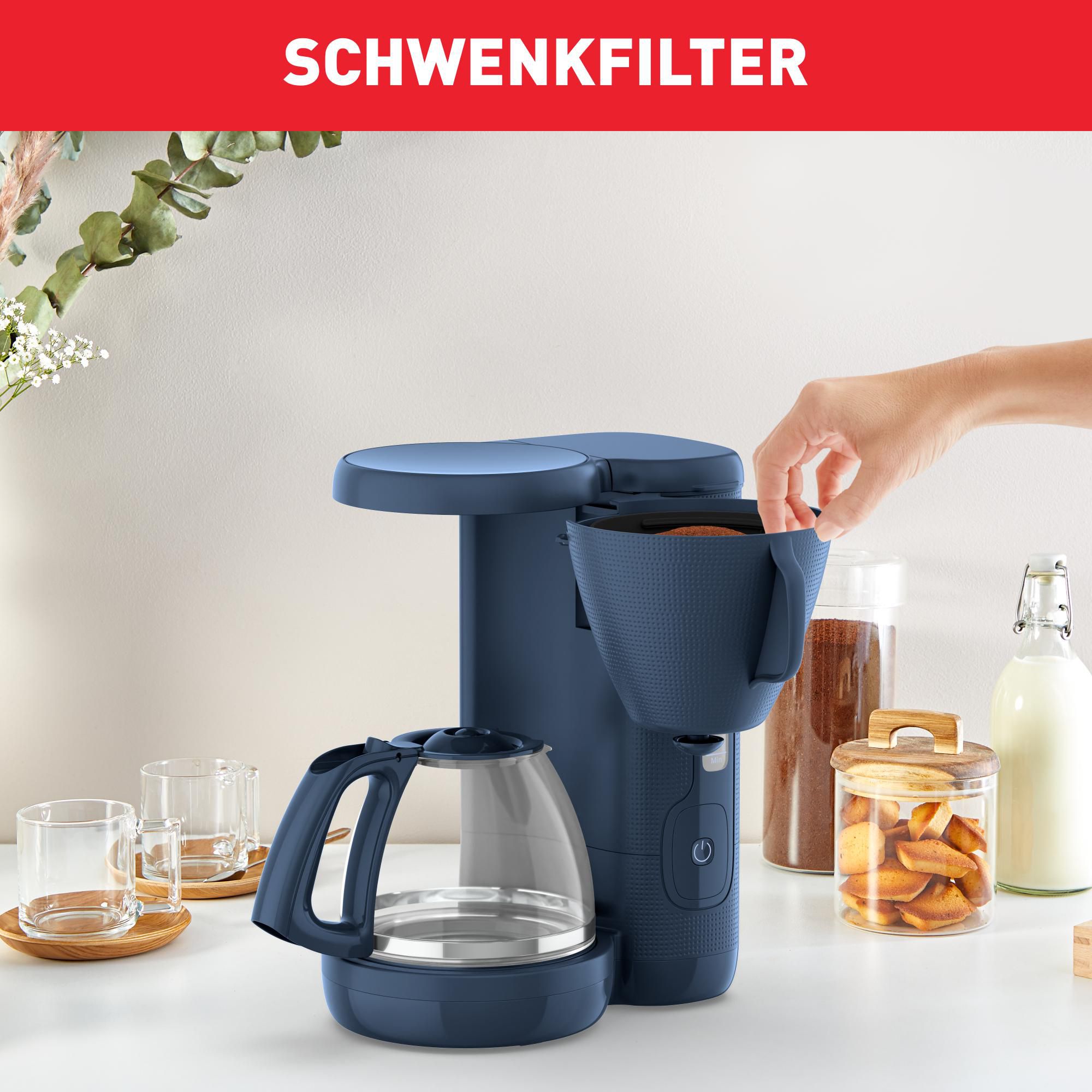 Blauer Kaffeemaschine und Zubehör. Eine Hand legt einen Filter ein. Text SCHWENKFILTER oben.