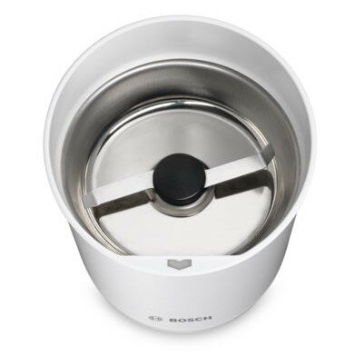 Widok z góry na biały młynek do kawy ze srebrnym wnętrzem i czarnym ostrzem.