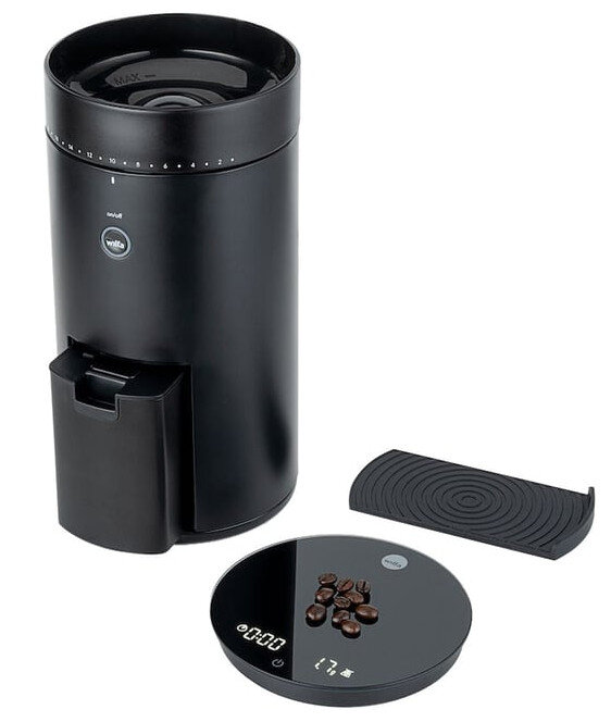 Czarny młynek do kawy z wagą, tacką i ziarnami kawy.