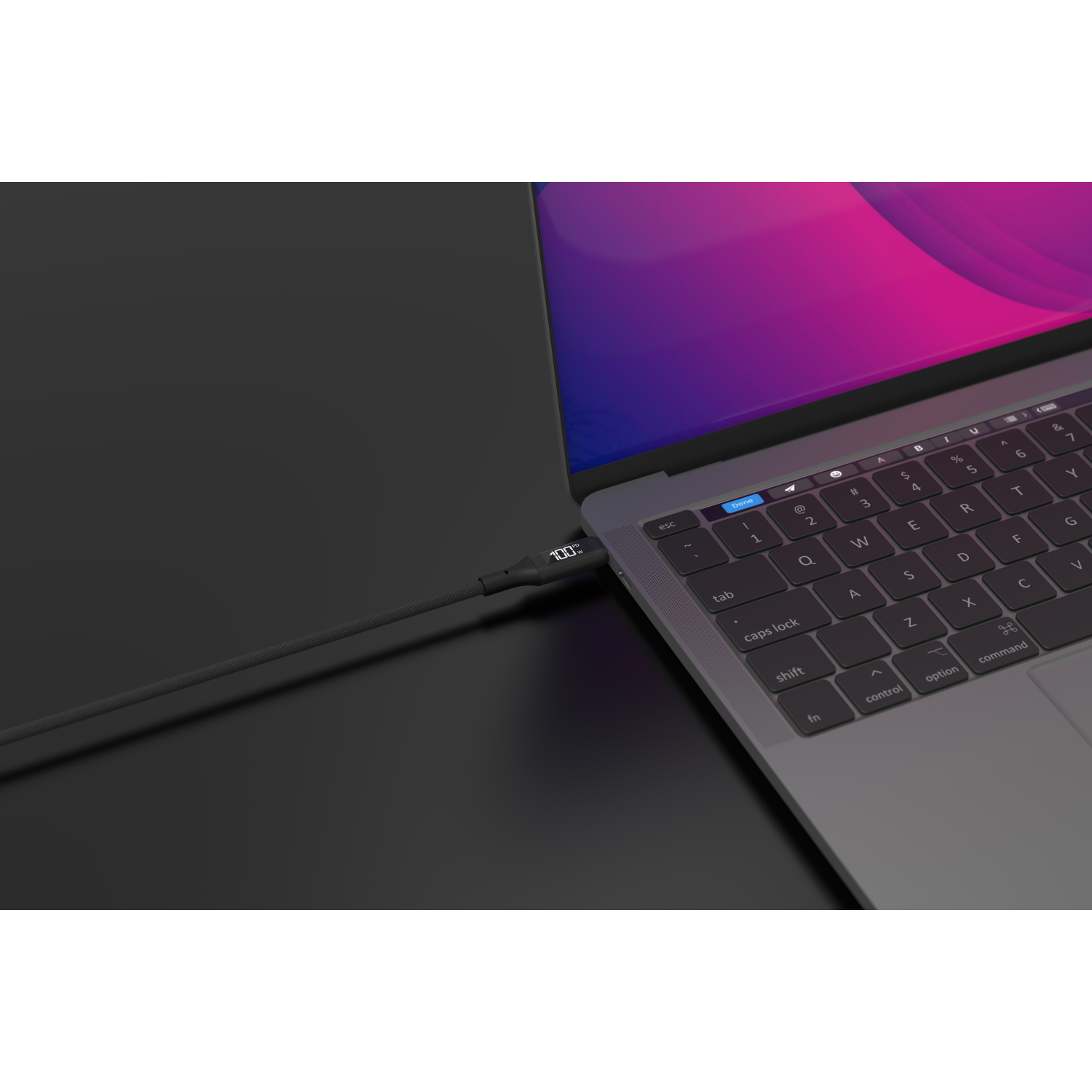 Laptop aangesloten op een oplaadkabel, met 100% lading weergegeven. Zwarte achtergrond.