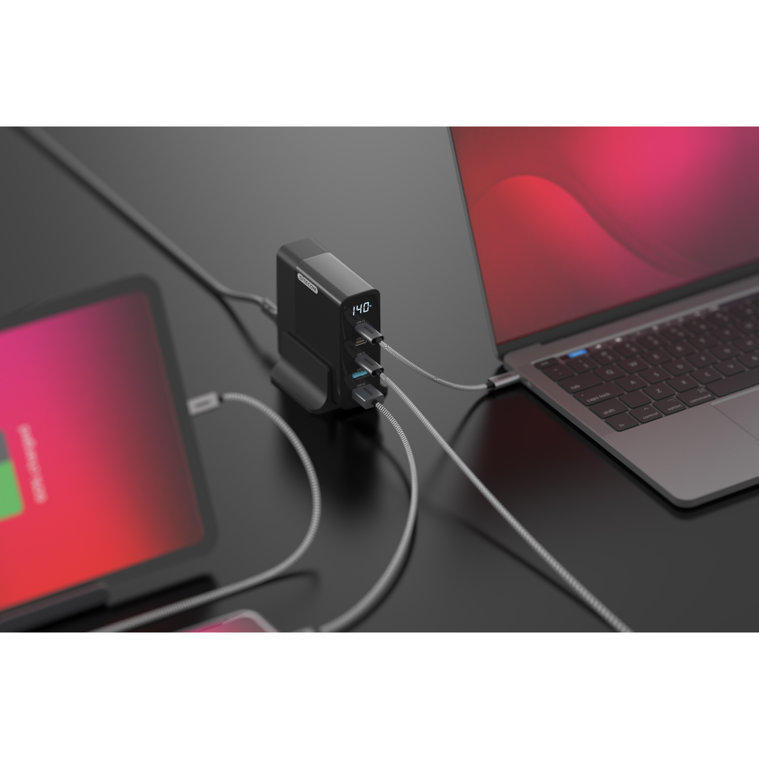 Black power adapter with multiple USB ports, charging devices on a dark surface.