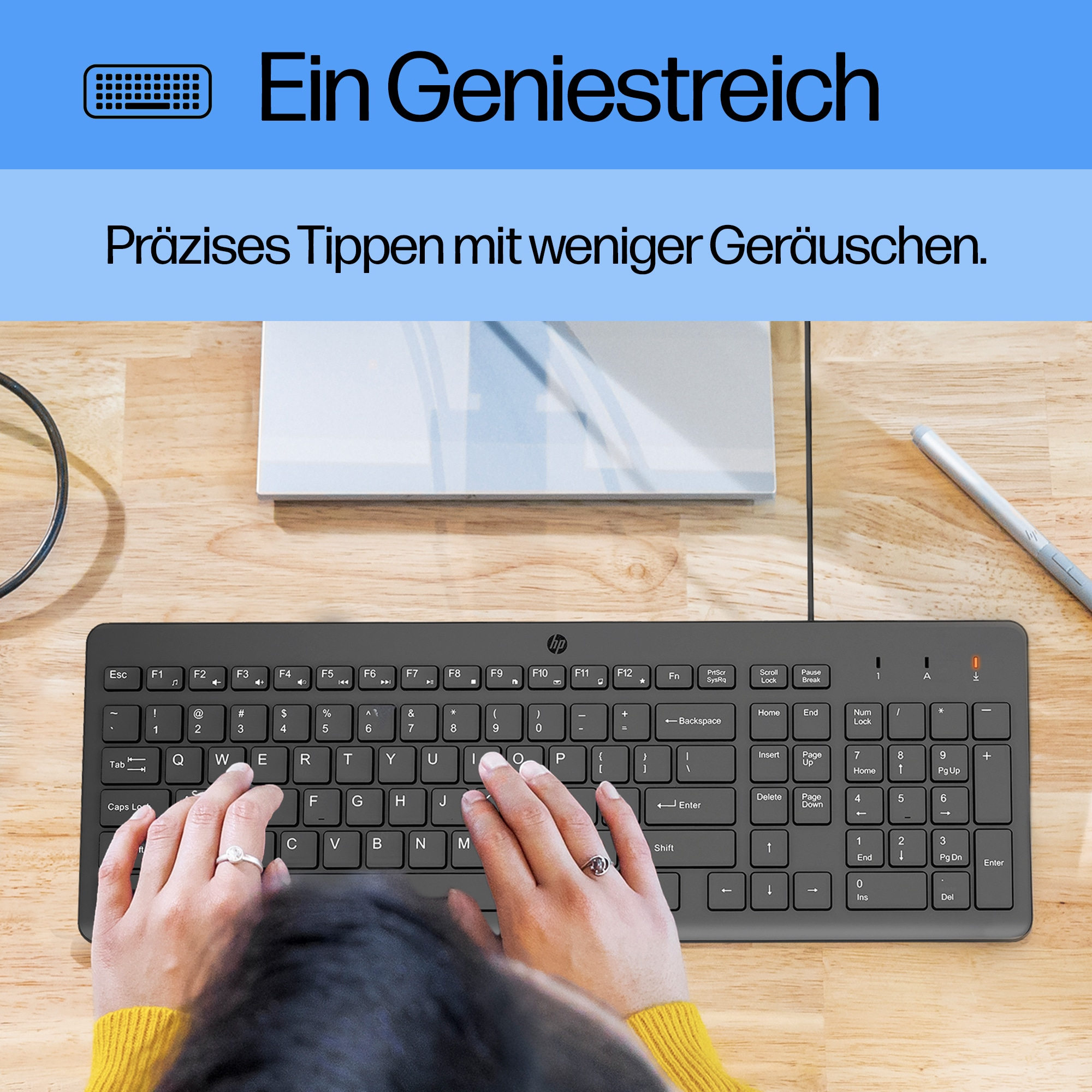 Hände tippen auf einer schwarzen HP-Tastatur. Die Szene umfasst einen Stift und Text auf Deutsch.