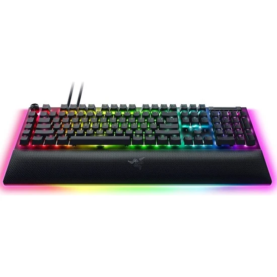Gökkuşağı LED aydınlatmalı siyah Razer klavye. Klavyenin bilek desteği var.