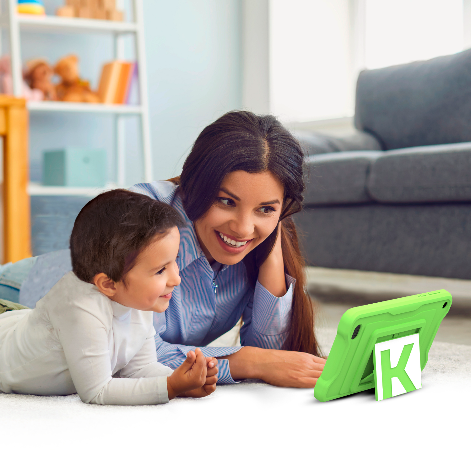 Een vrouw en een kind liggen en bekijken een tablet met een groene hoes.